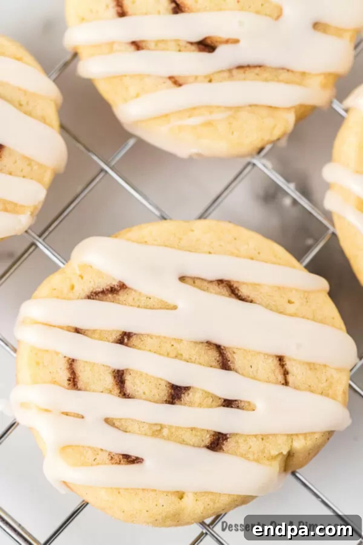 Close-up of stacked Cinnamon Roll Cookies with generous icing.