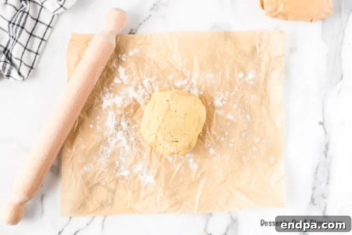 Dough rolled out on parchment paper with a light dusting of flour.
