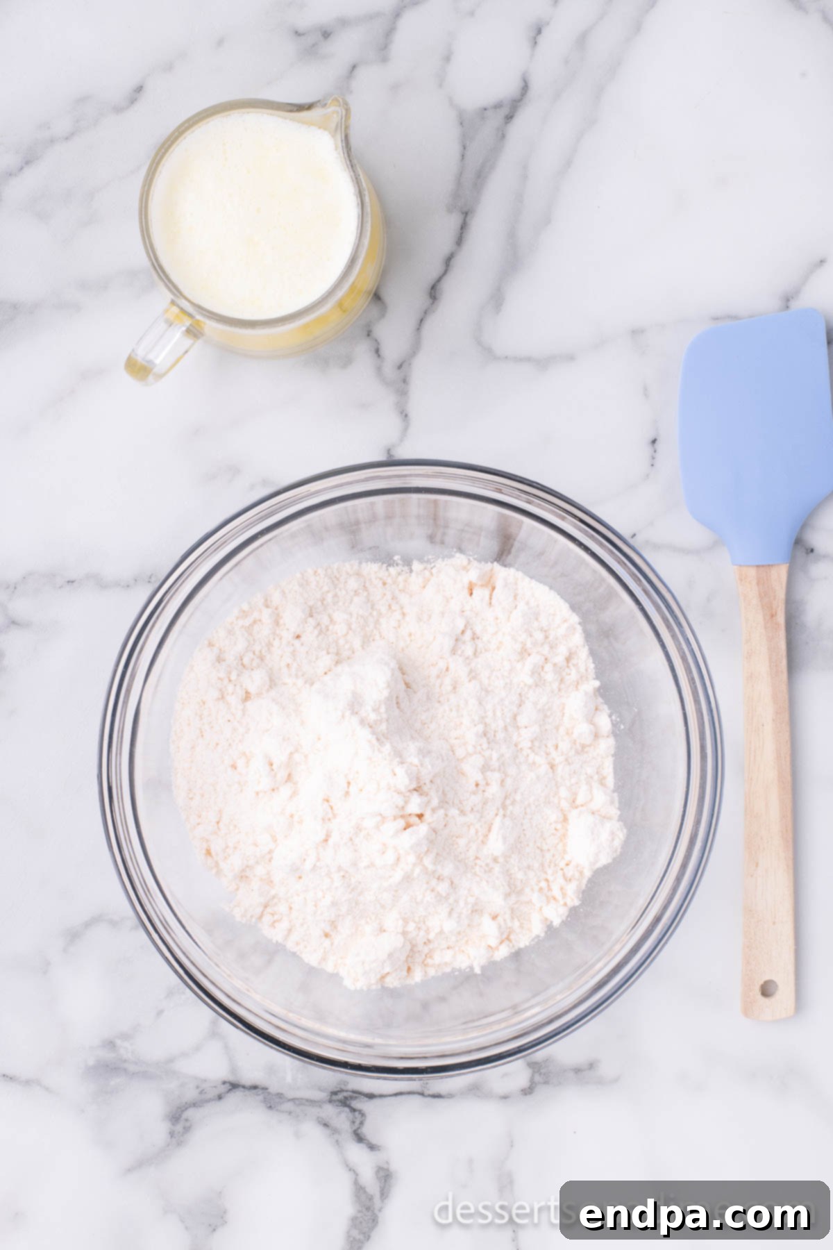 Dry yellow cake mix is shown in a mixing bowl, ready to be combined with melted butter for the cake topping.