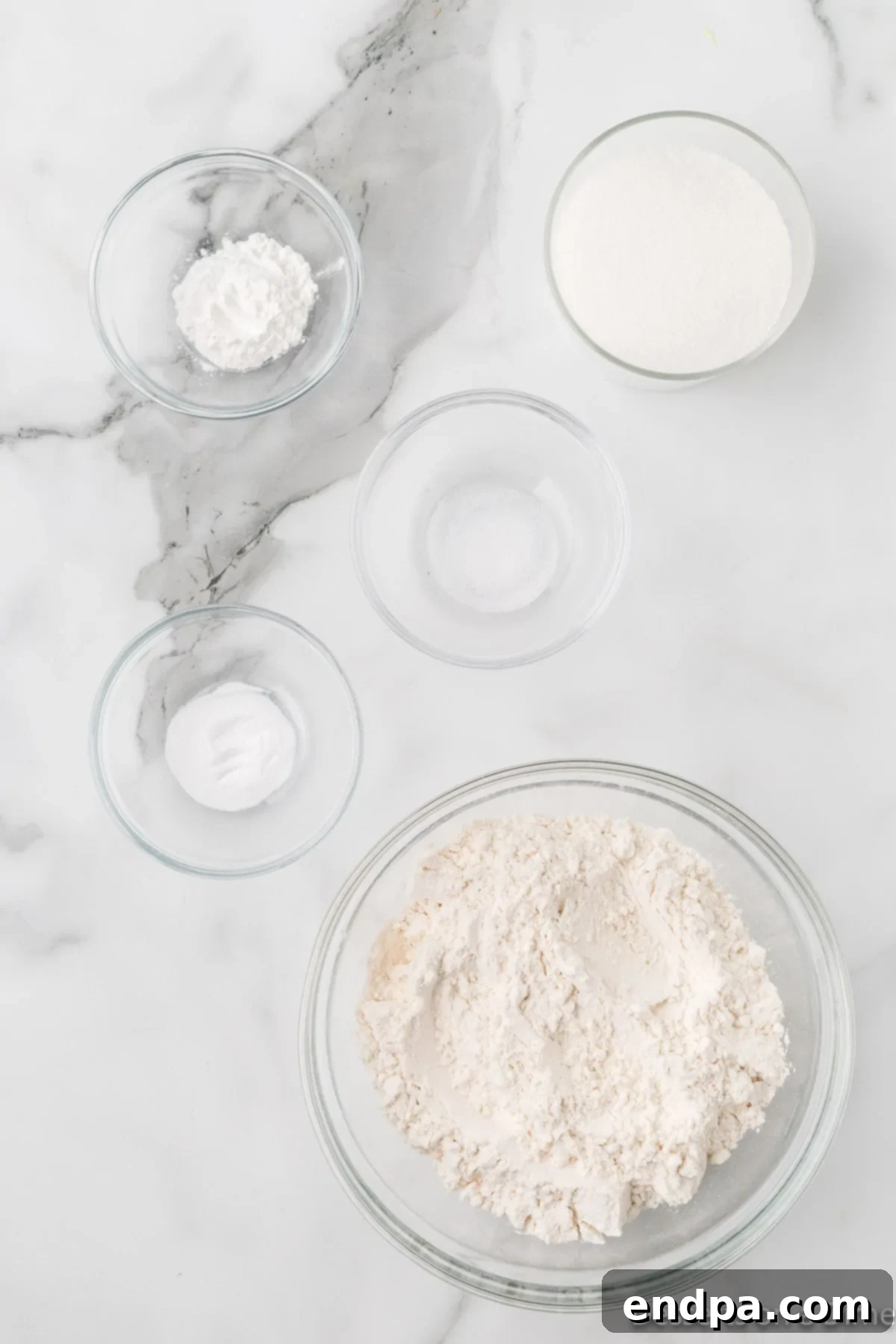 Collection of dry and wet ingredients for homemade cake mix including flour, sugar, baking powder, baking soda, salt, milk, oil, eggs, and vanilla.