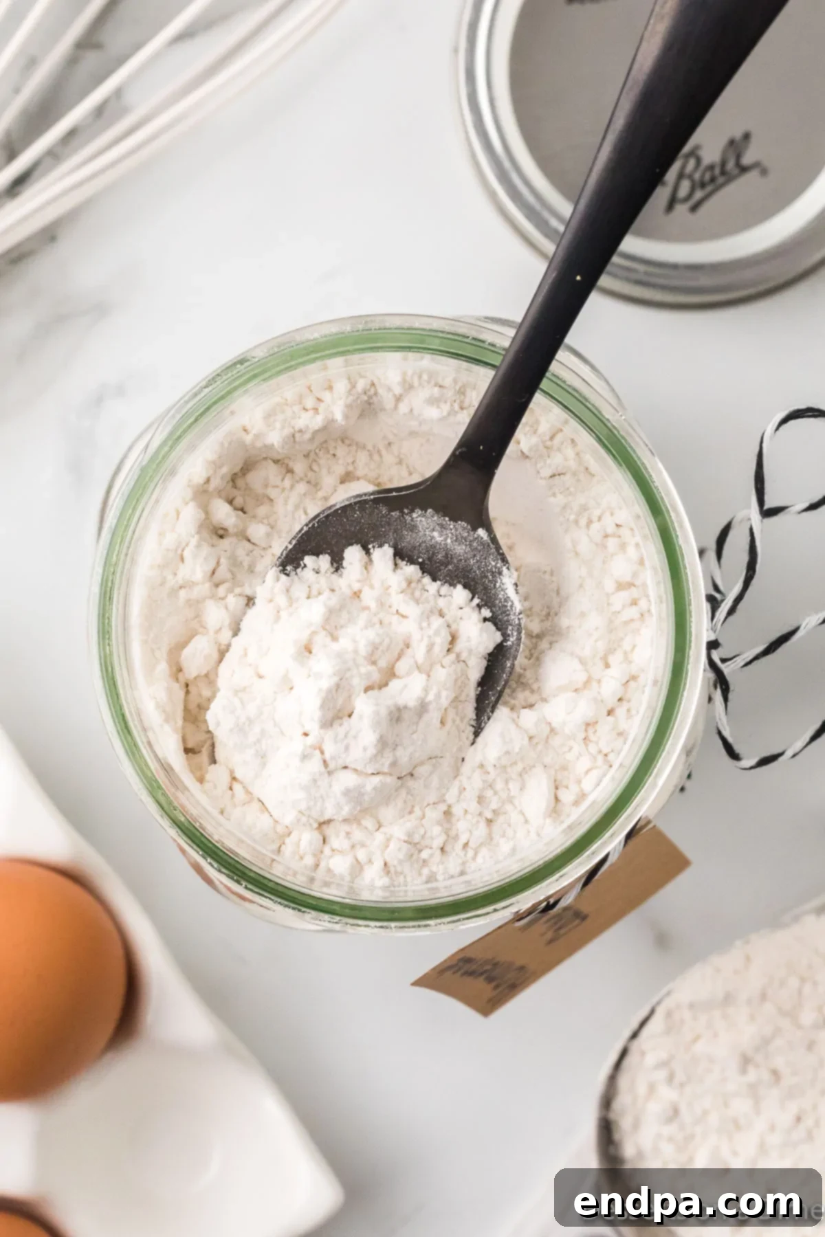 A mason jar with the combined dry ingredients for the homemade cake mix.