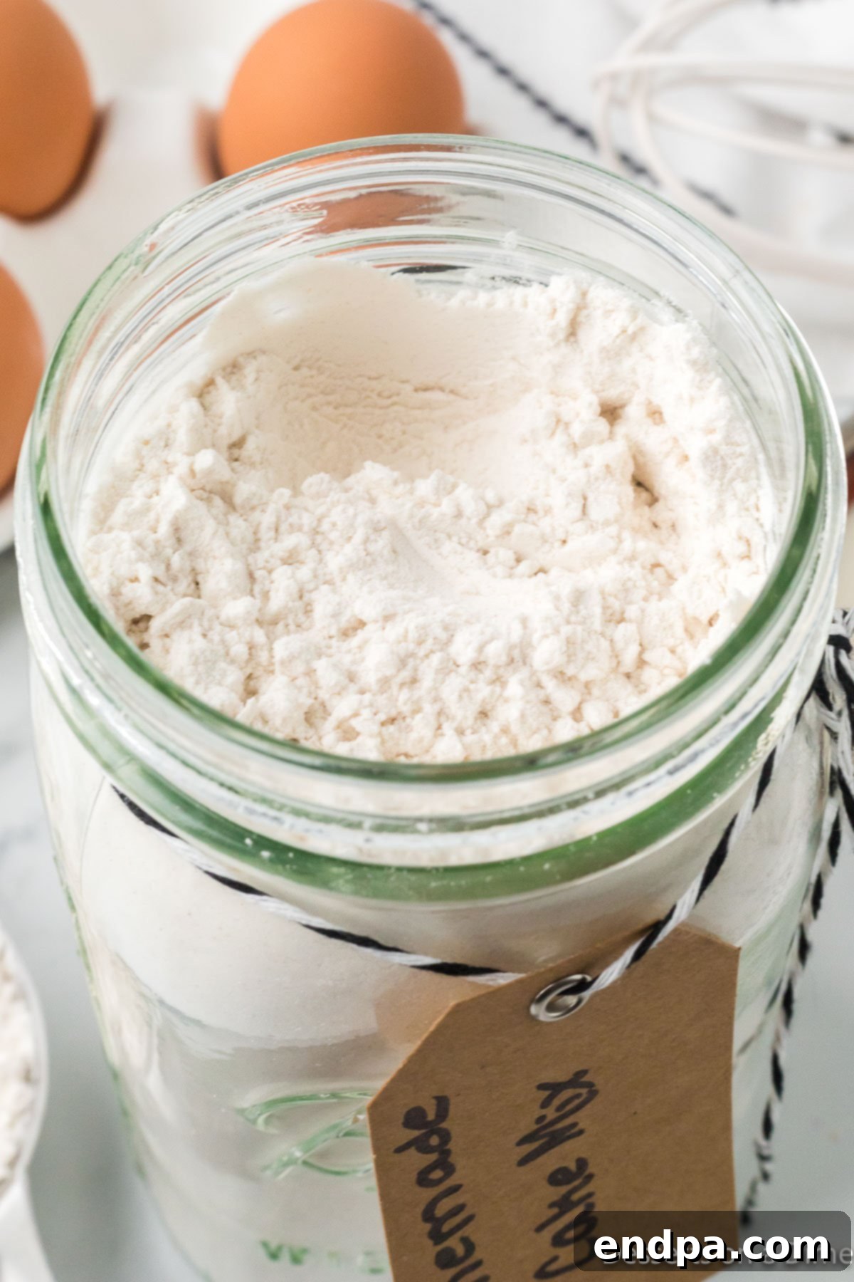 Another view of a mason jar filled with dry ingredients for homemade cake mix, ready to be stored.