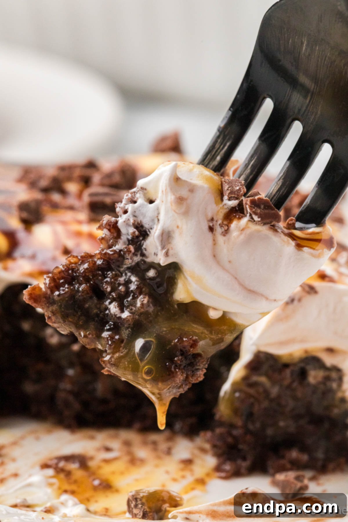 Gooey Chocolate Caramel Poke Cake 2 Chocolate Caramel Poke cake with a fork.