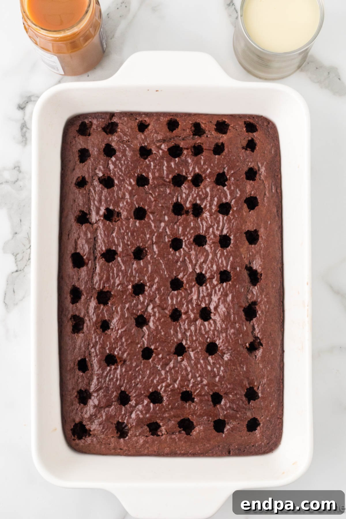 Gooey Chocolate Caramel Poke Cake 5 Holes poked all over cake.