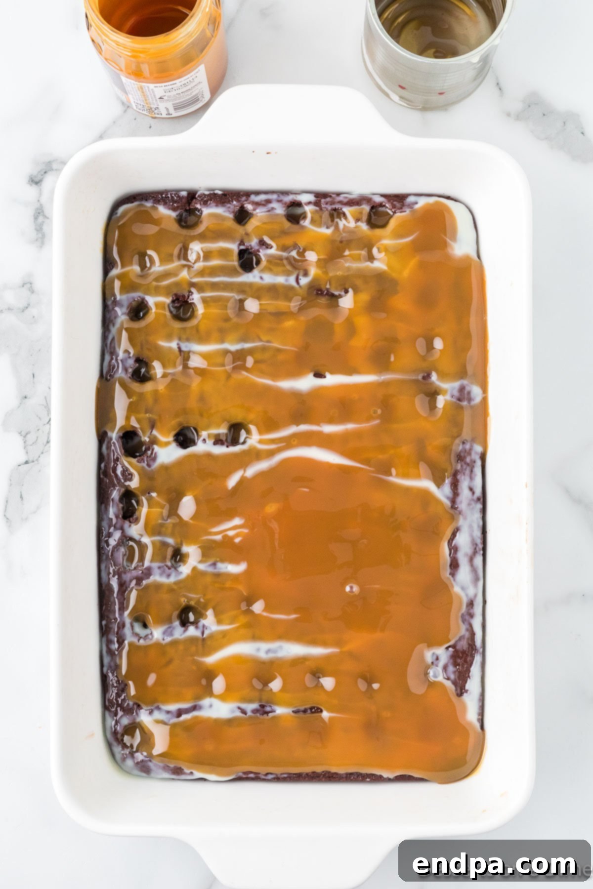 Gooey Chocolate Caramel Poke Cake 6 Caramel spread over cake.