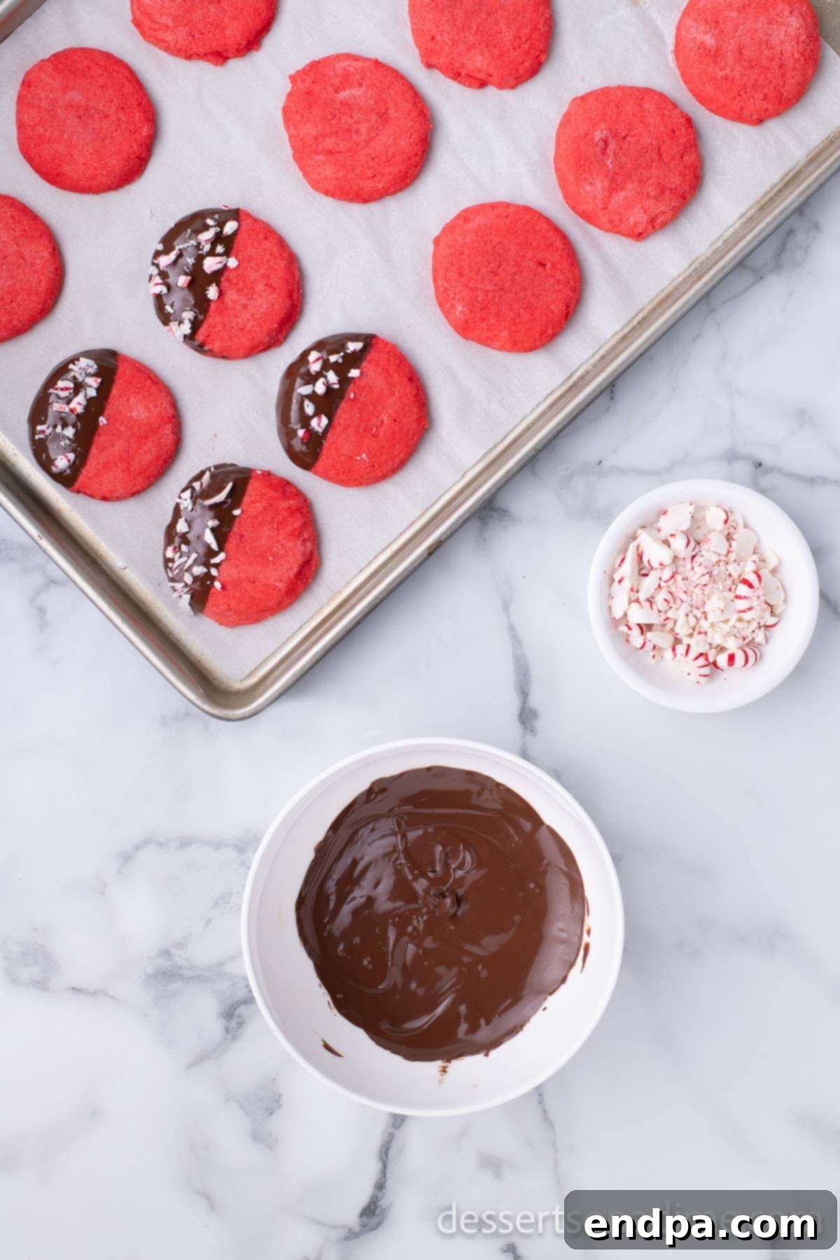 Dark Chocolate-Dipped Peppermint Cookie Delights 12 A baked cookie being dipped into melted chocolate.