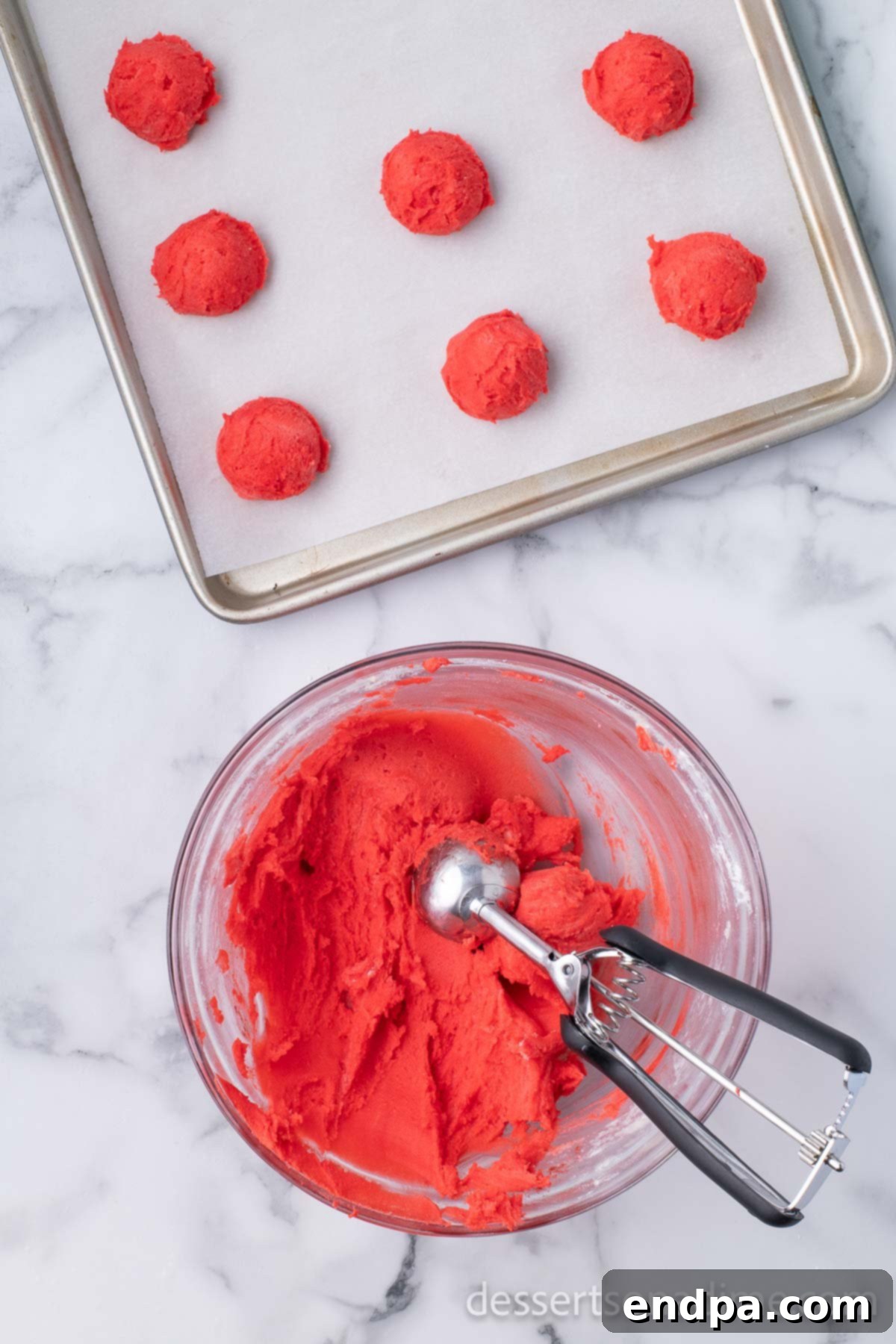 Dark Chocolate-Dipped Peppermint Cookie Delights 7 Cookie scoop in a bowl of red peppermint cookie dough.