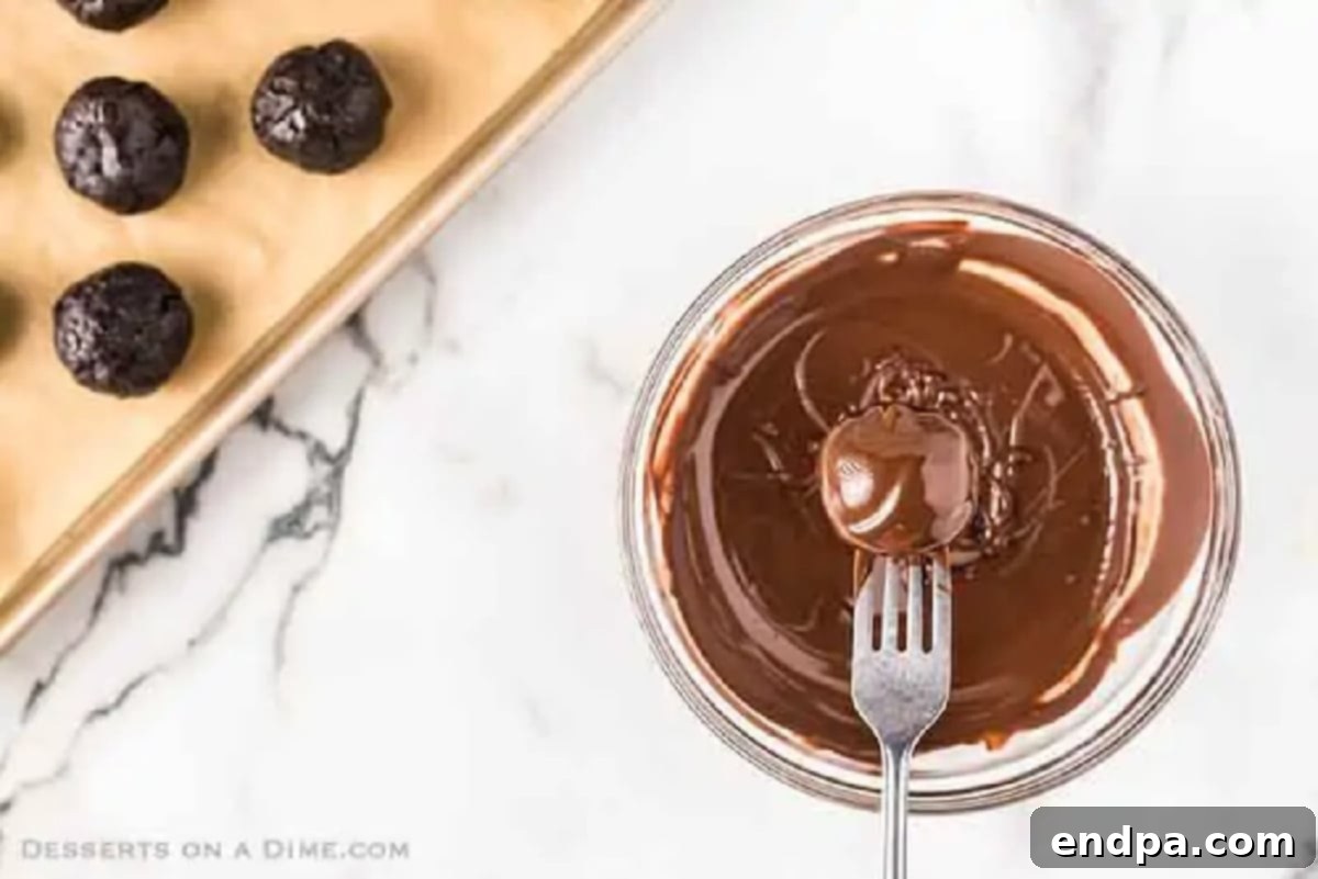 Decadent No-Bake Oreo Truffles 5 Oreo Balls being dipped into melted chocolate, showing a smooth coating