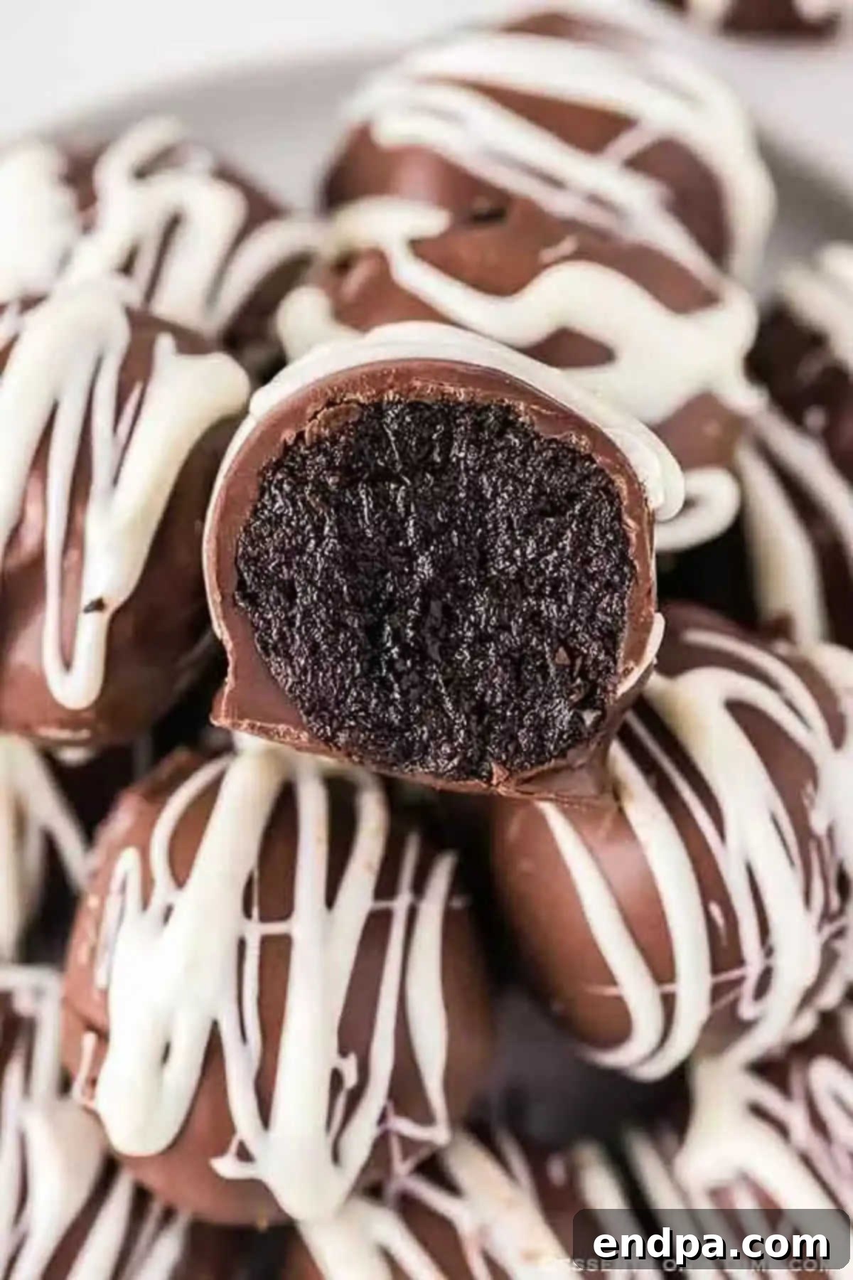 Indulge in these delicious stacked Oreo Balls, perfect for any occasion and easy to make with our no-bake recipe. Stacked No Bake Oreo Balls, featuring a white chocolate drizzle and perfect coating