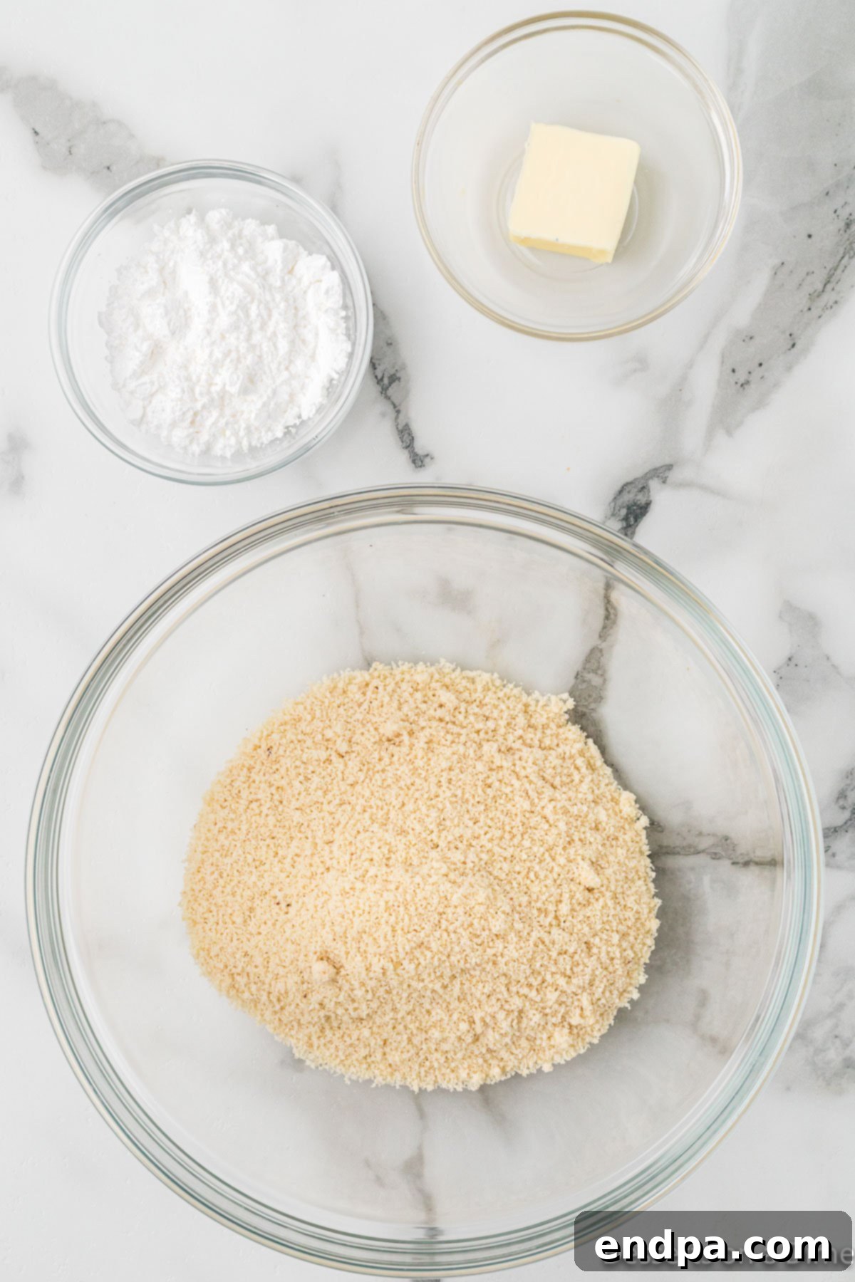 Keto Cookie Dough Bliss 4 Dry ingredients for keto cookie dough, including almond flour and powdered sweetener, are combined in a large mixing bowl.