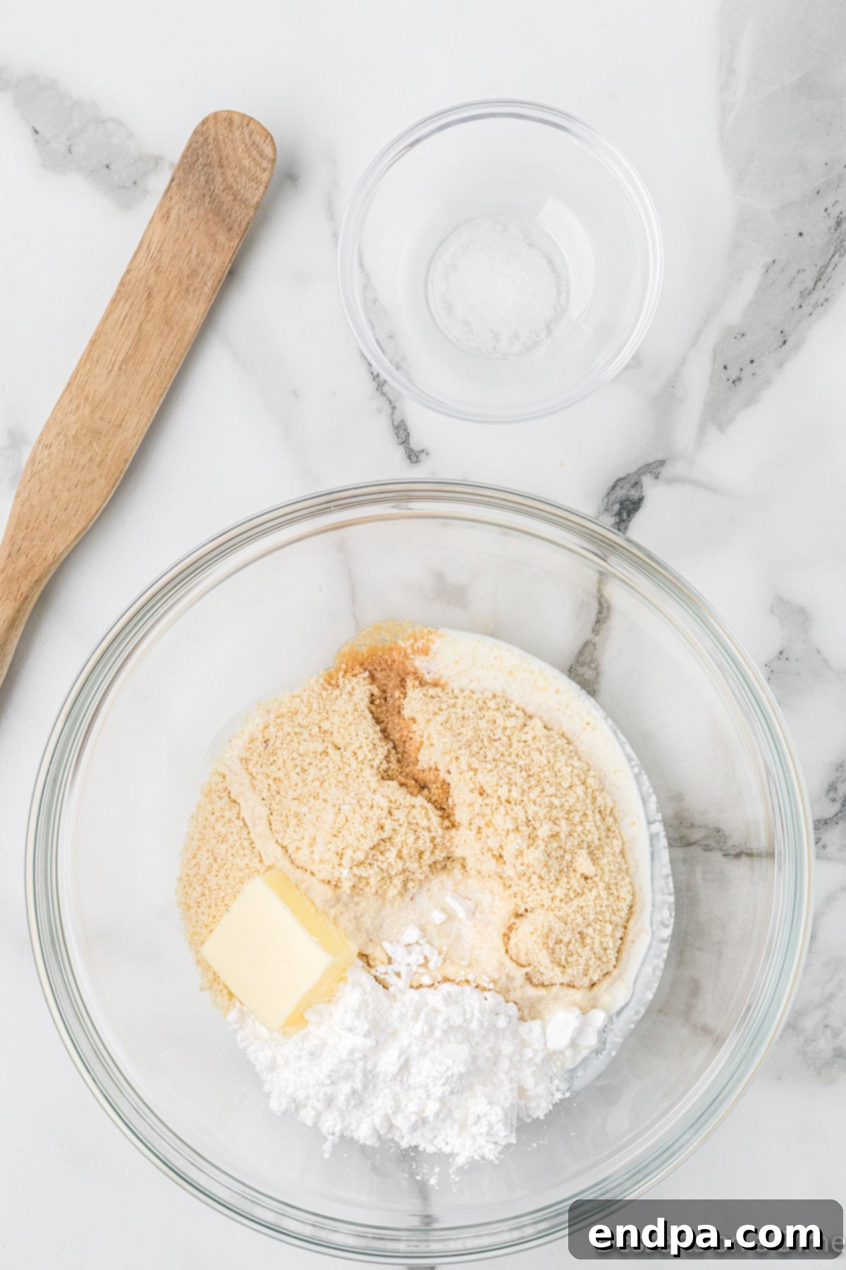 Keto Cookie Dough Bliss 5 Wet ingredients, including softened butter and heavy cream, are added to the dry mixture in a bowl and being blended.