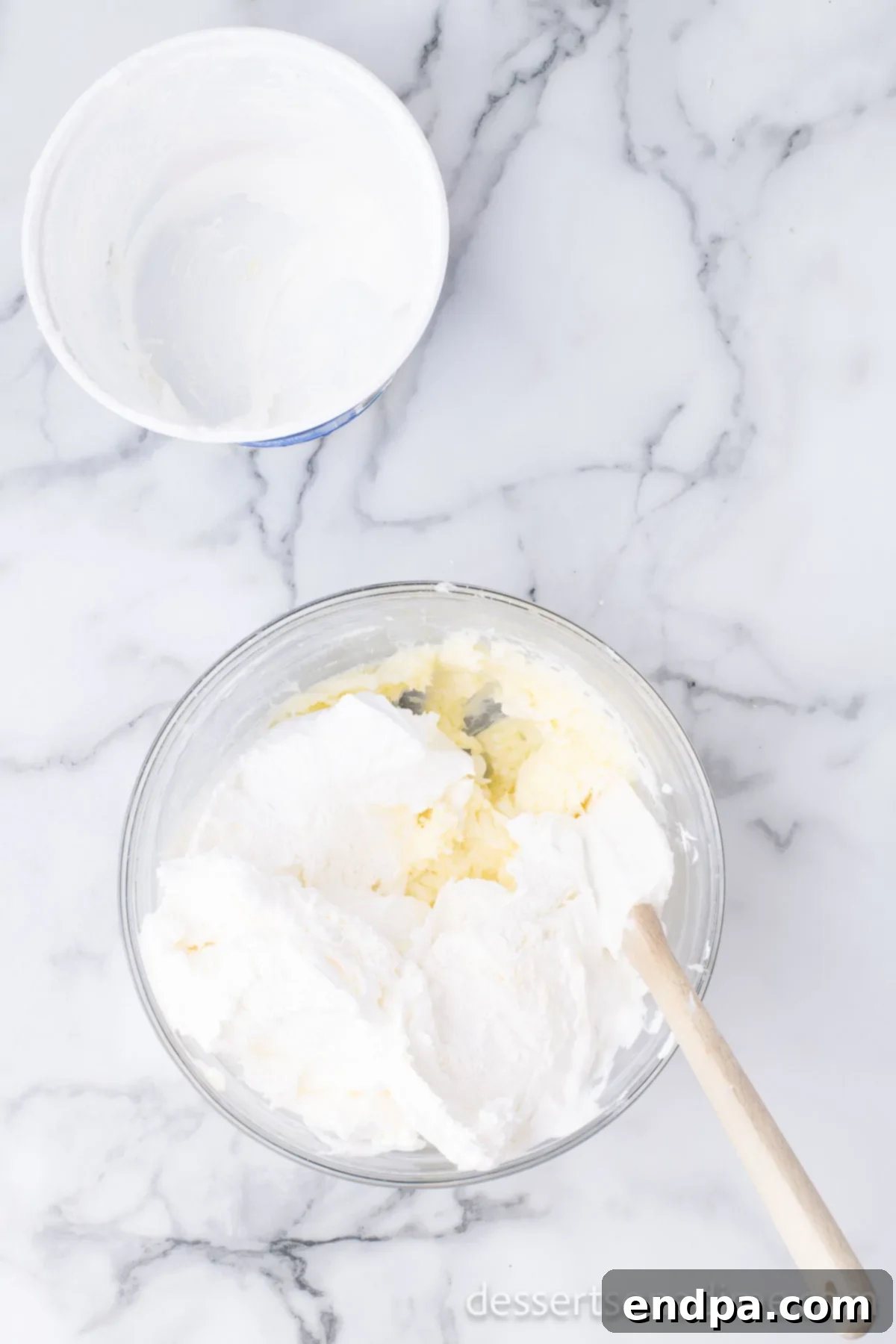 Cream cheese mixture being combined in a large bowl, showing its smooth texture.
