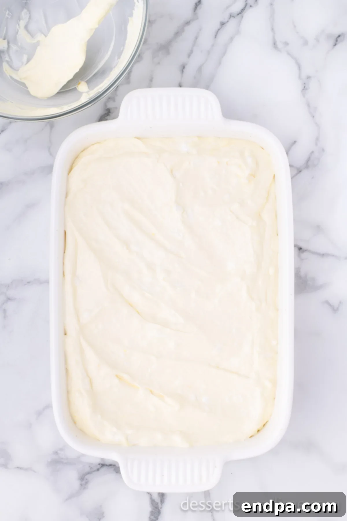 The creamy pudding and cream cheese mixture spread over the crushed Oreo base in the baking dish.