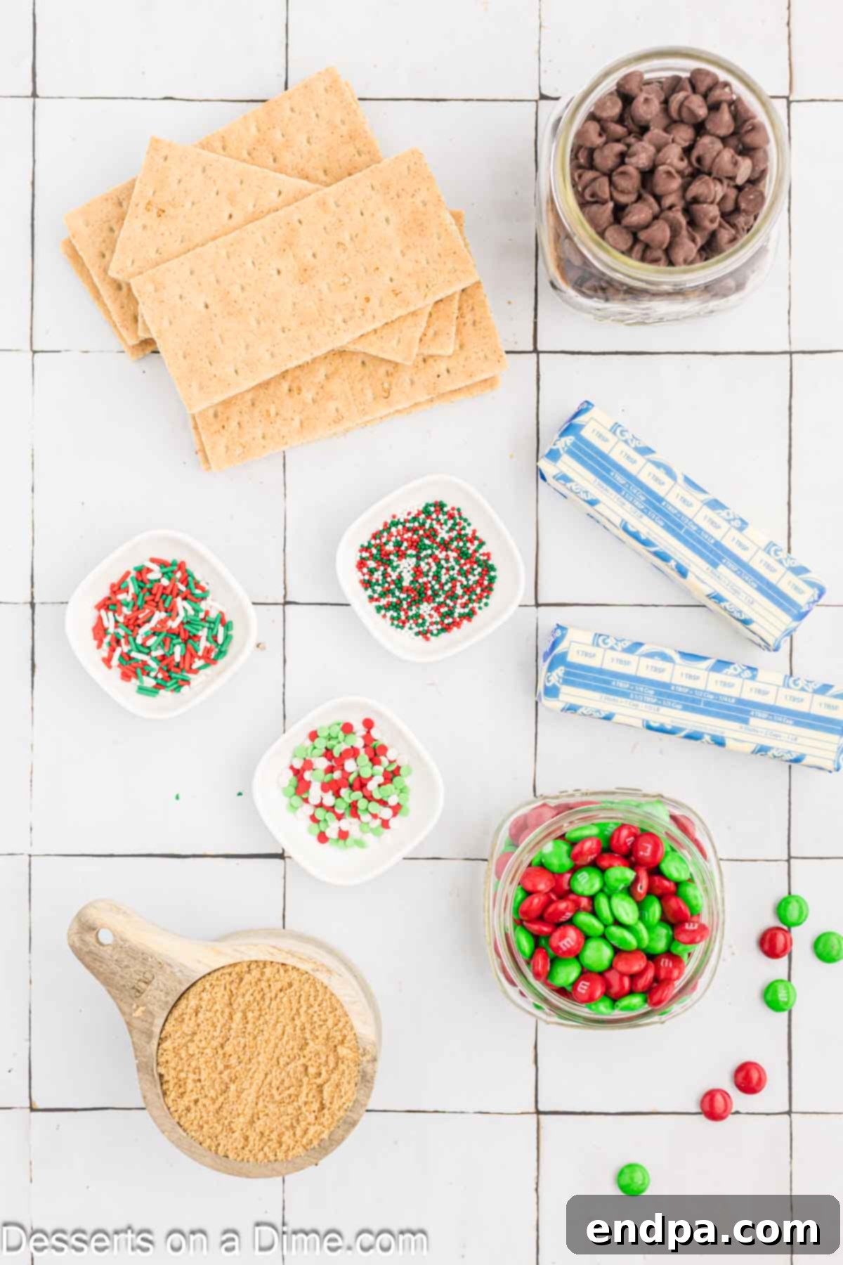 Ingredients for chocolate bark - graham crackers, butter, brown sugar, chocolate chips, red and green M&Ms, Christmas sprinkles.