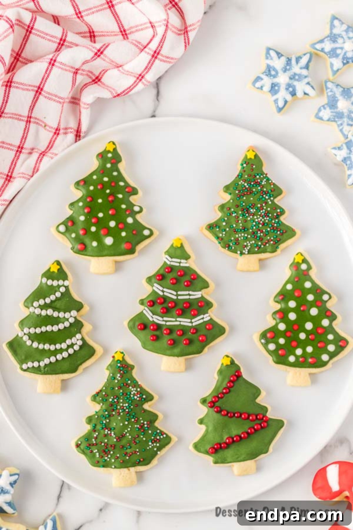 Assortment of beautifully decorated Christmas Sugar Cookies on a white plate, ready to be enjoyed.