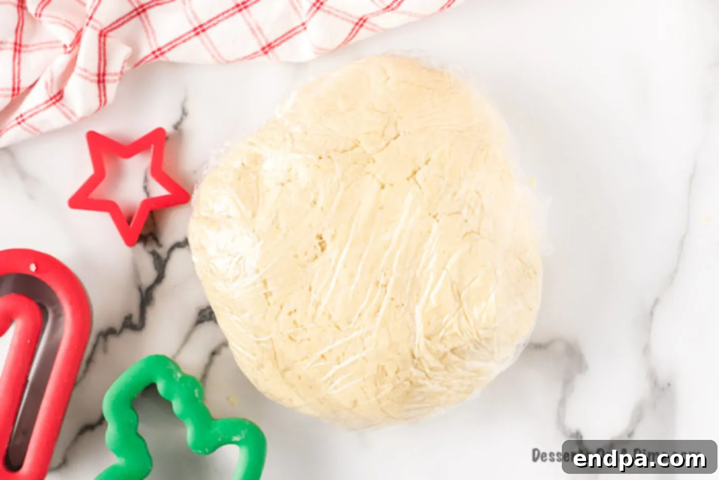 Cookie dough wrapped tightly in plastic wrap, ready for chilling.