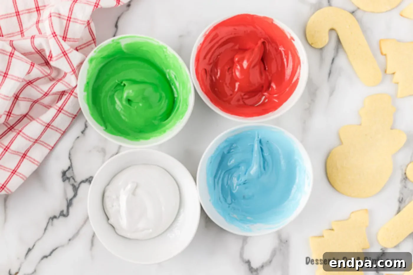 Multiple bowls containing royal icing in different vibrant colors.