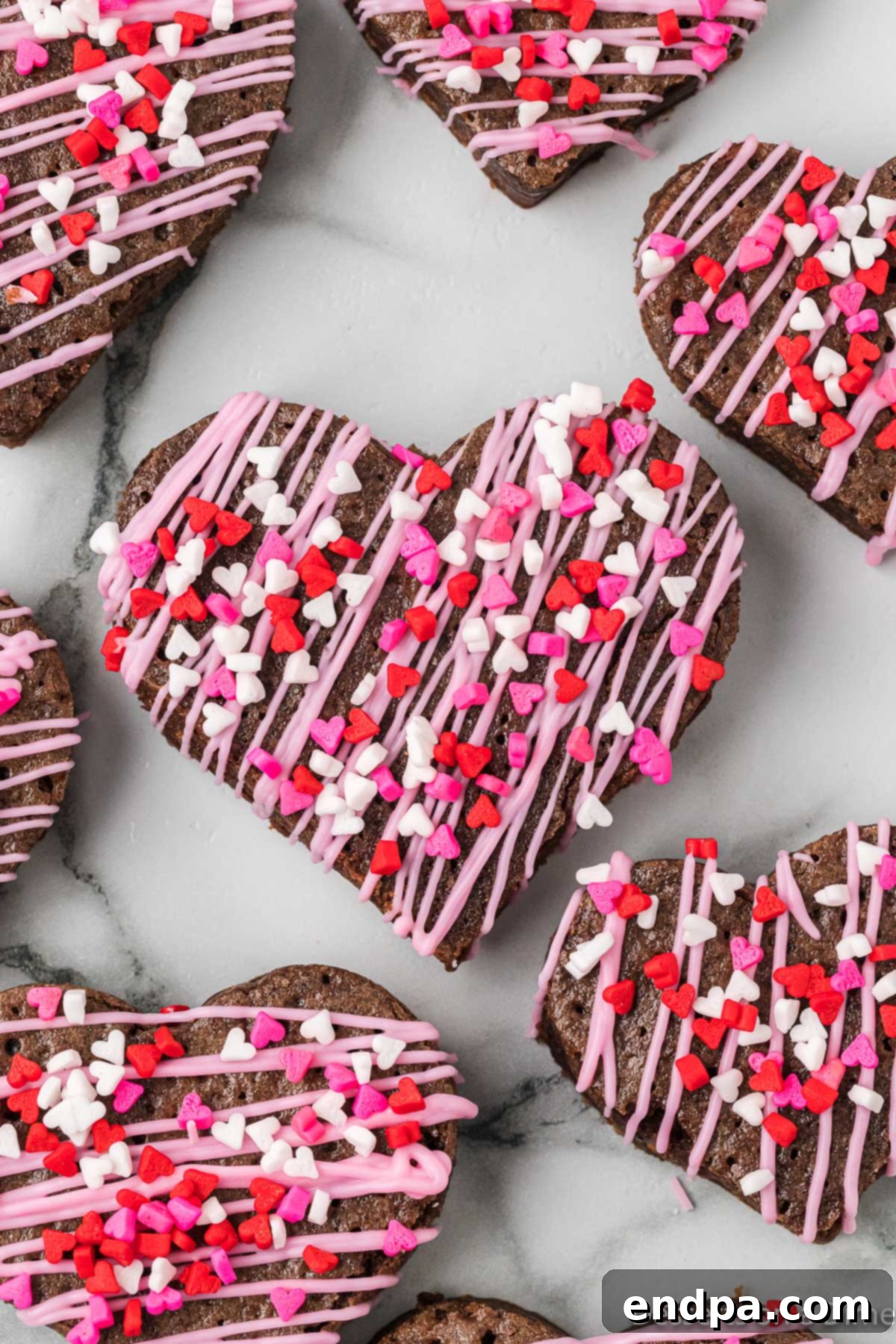 Sweetheart Brownies 2 Fudgy brownies cut into charming heart shapes, adorned with pink candy melts and colorful sprinkles.