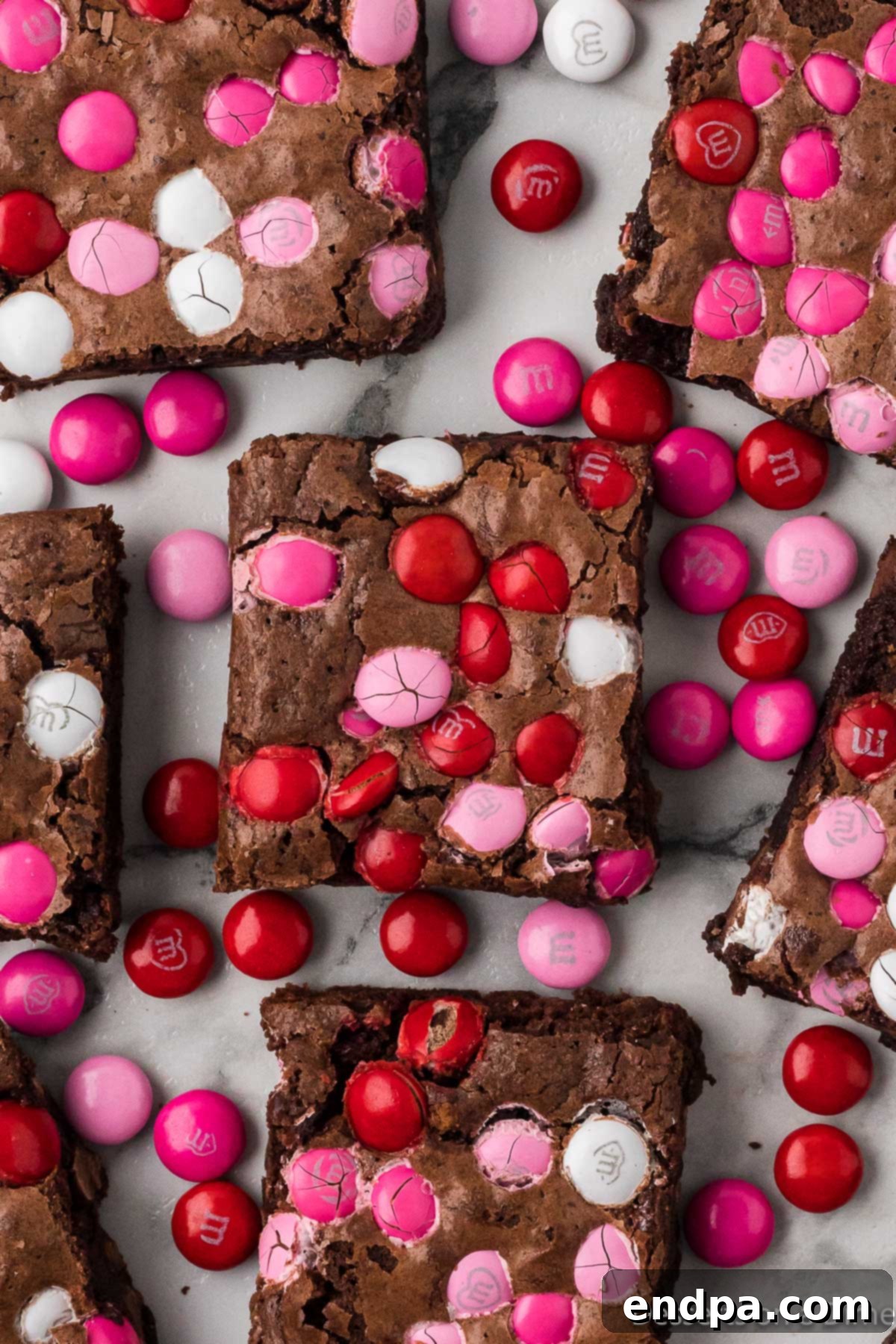 Fudgy Valentine's Brownies cut into perfect squares, showcasing pink and red M&Ms and melted chocolate chips.