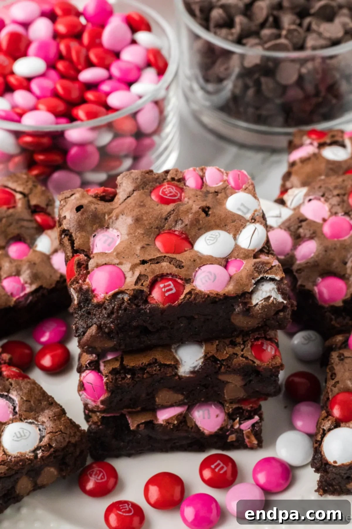 Stack of fudgy Valentine's Day Brownies, showing their thick, chocolatey texture and colorful M&M topping.
