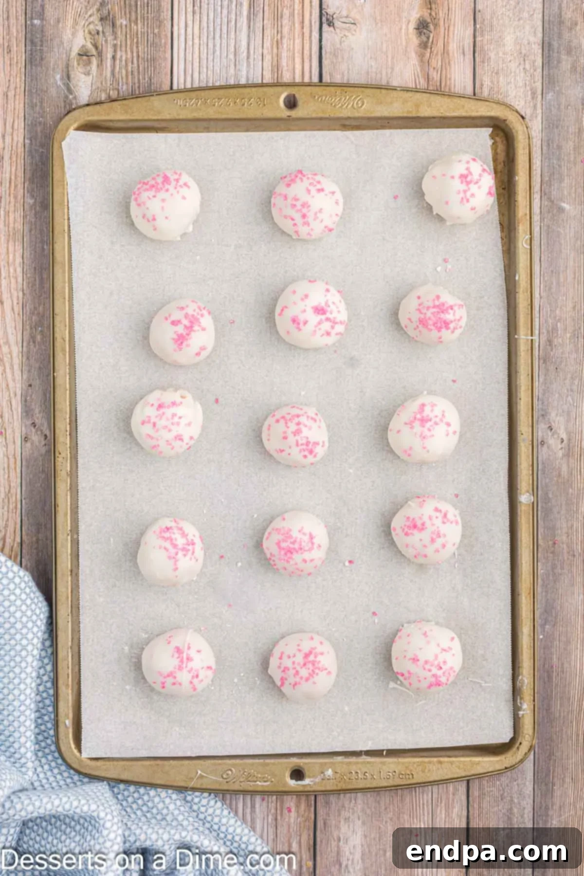 Strawberry truffles adorned with pink sprinkles before the chocolate sets.