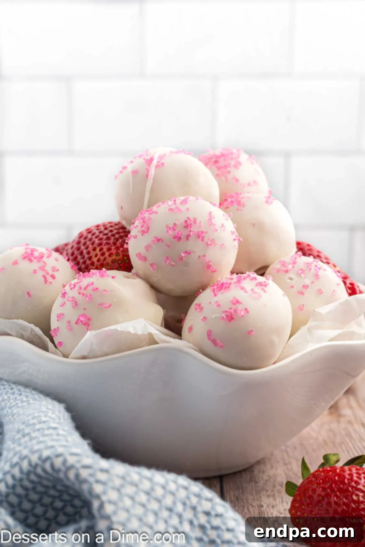 A close-up of a beautifully coated strawberry truffle, ready to be enjoyed.