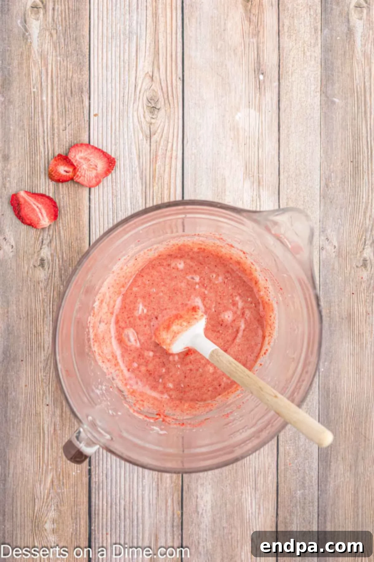The strawberry dust being stirred into the melted white chocolate ganache mixture.