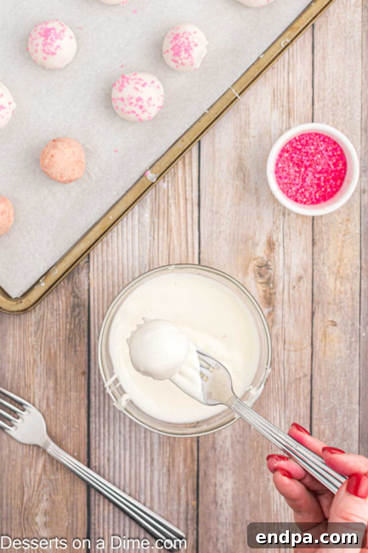 A fully coated strawberry truffle resting on wax paper.