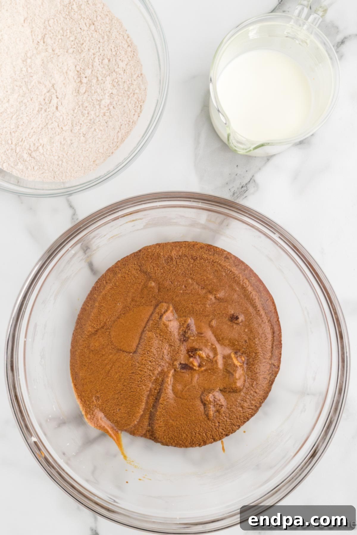 An electric mixer actively blending the dry ingredients, buttermilk, and the creamed butter-sugar-molasses mixture in a large bowl, showing the gingerbread cake batter coming together.