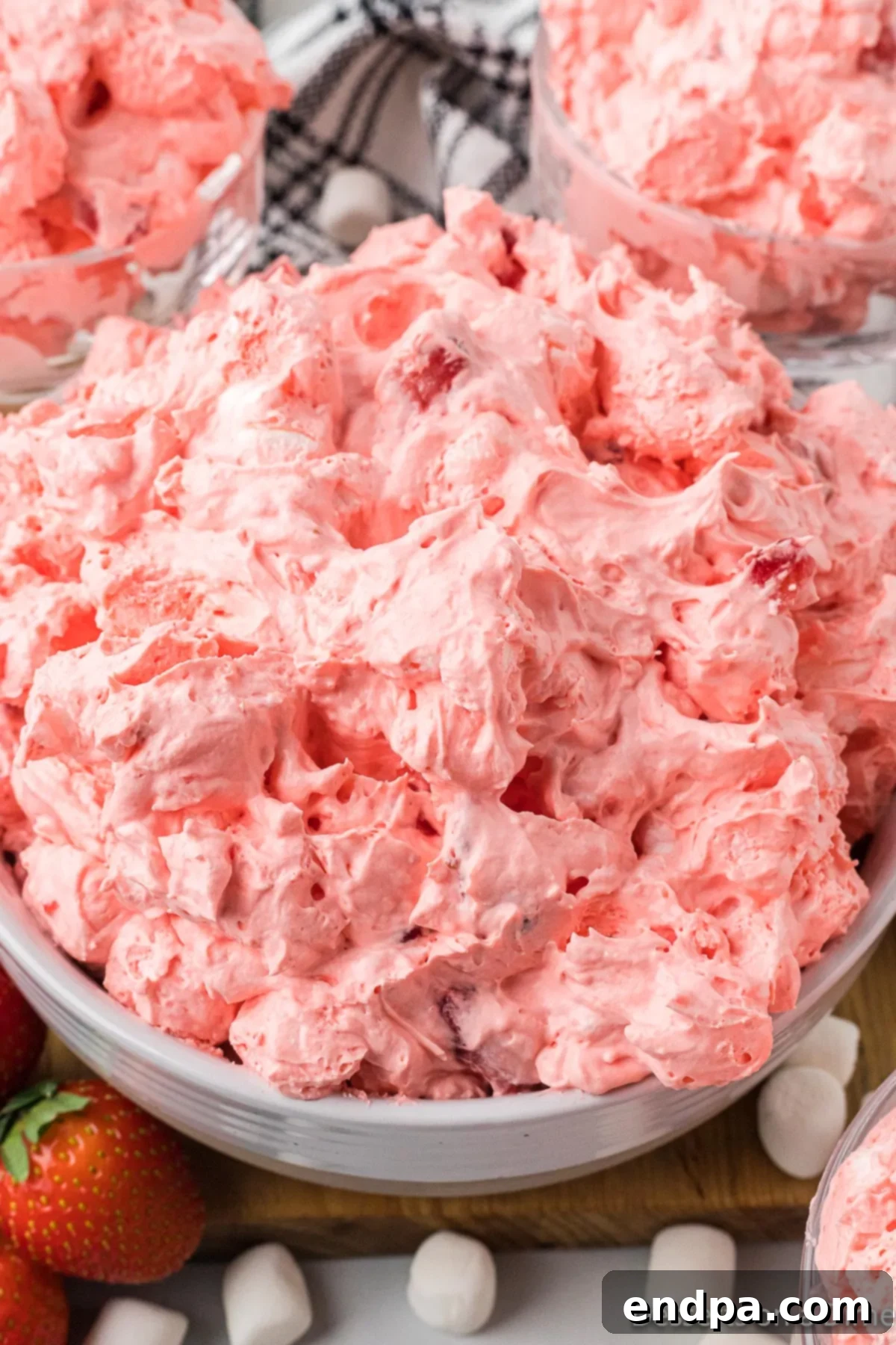 Strawberry Cloud Delight 8 The fully blended Strawberry Fluff Salad in a large mixing bowl, showcasing its light pink color and fluffy texture with visible marshmallows and strawberry pieces.