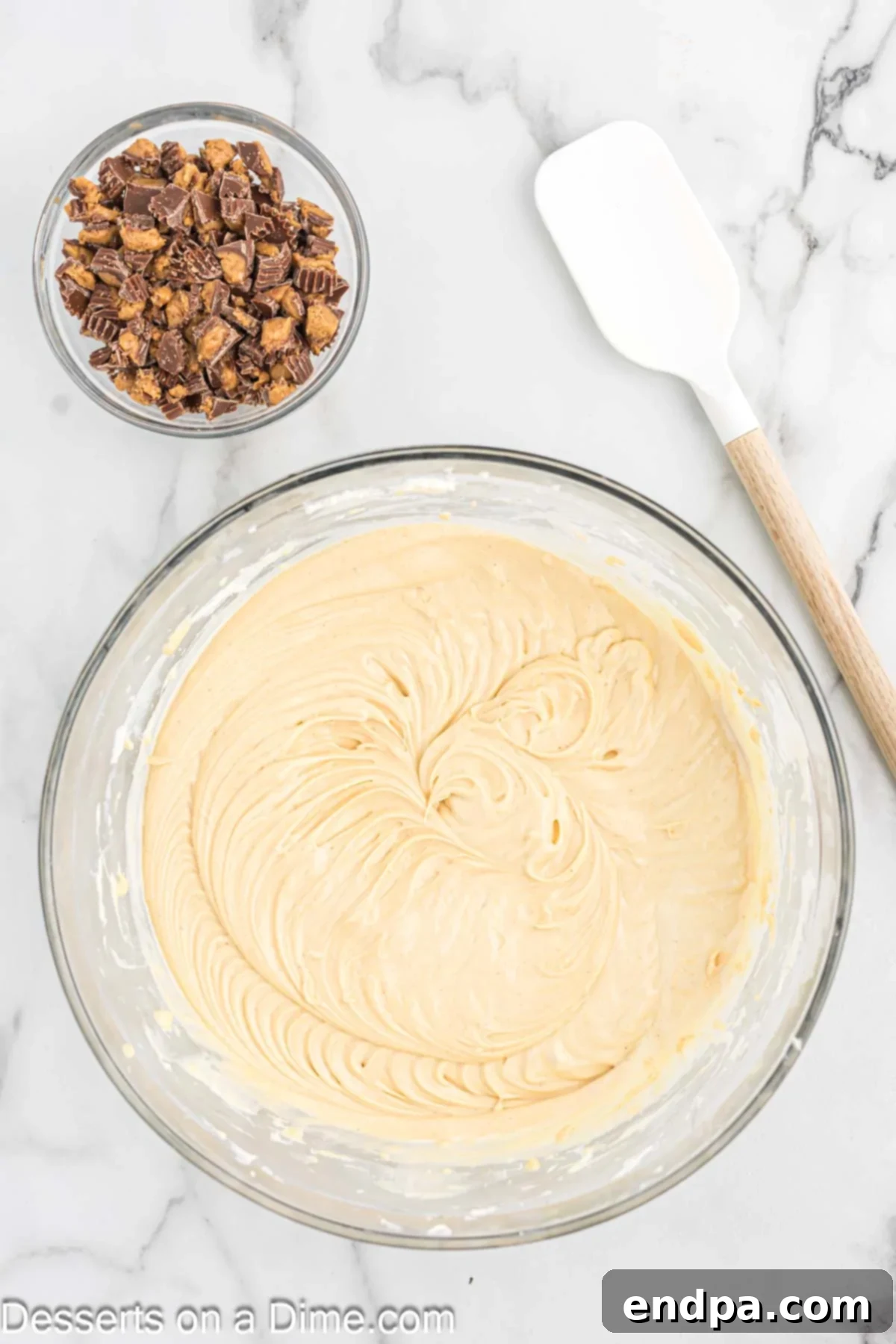 Mixture combined in bowl. Chopped peanut butter cups folded into the bowl. 