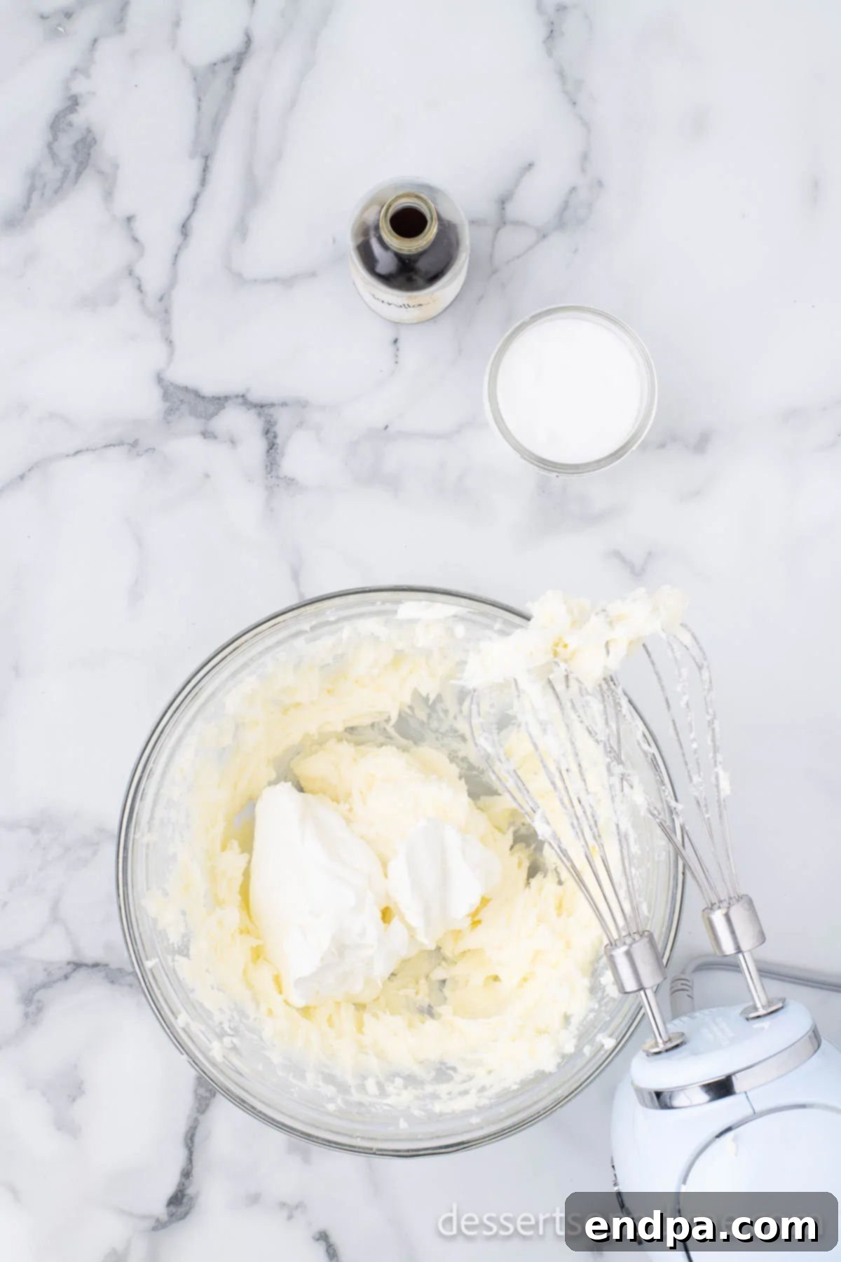 Heavenly Oreo Cheesecake Treats 7 Sour cream being added to the cream cheese and sugar mixture.