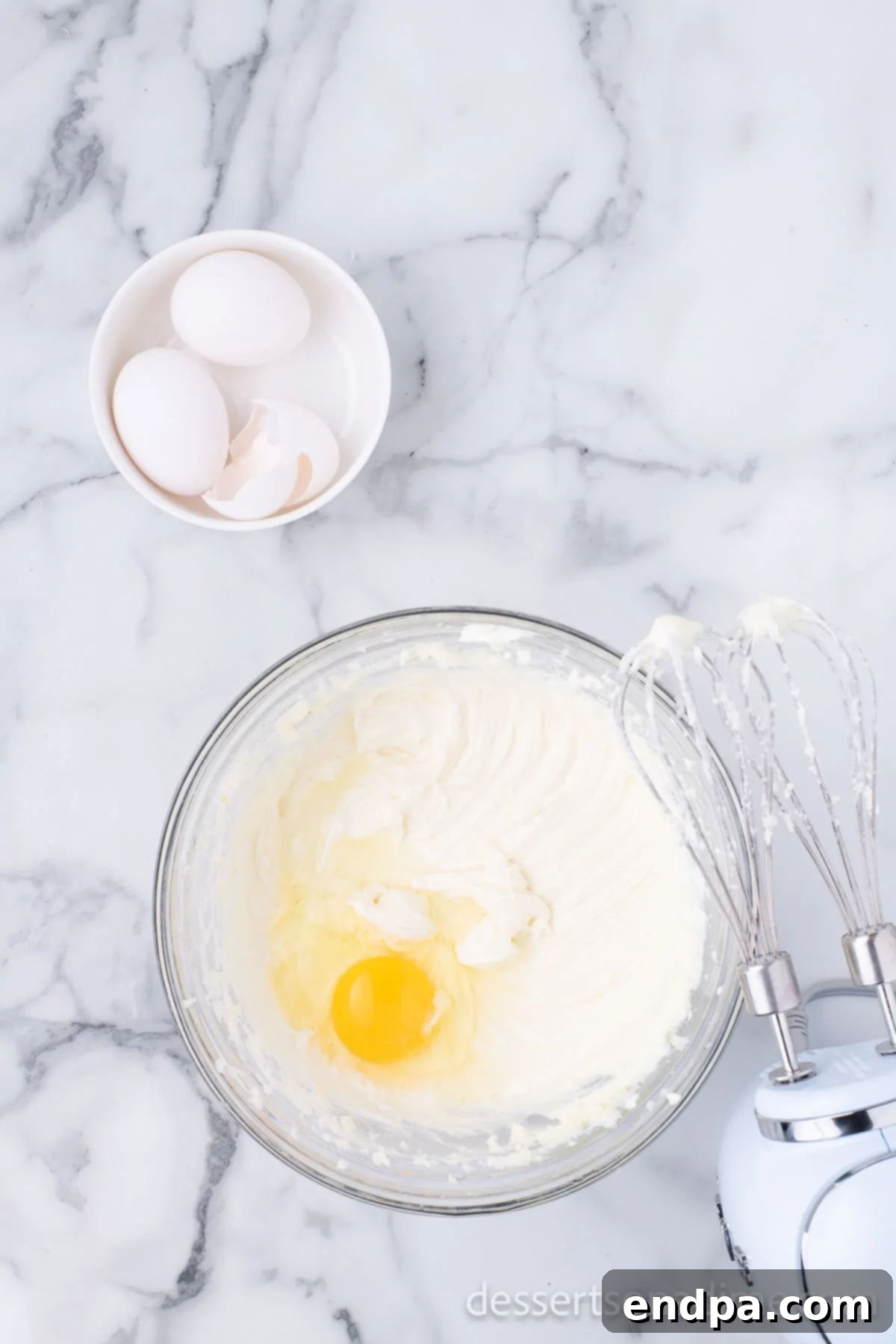 Heavenly Oreo Cheesecake Treats 8 Eggs being added one at a time to the cheesecake batter.