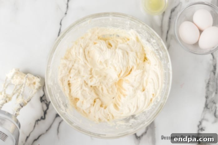 Cream cheese mixture being combined in a large mixing bowl.