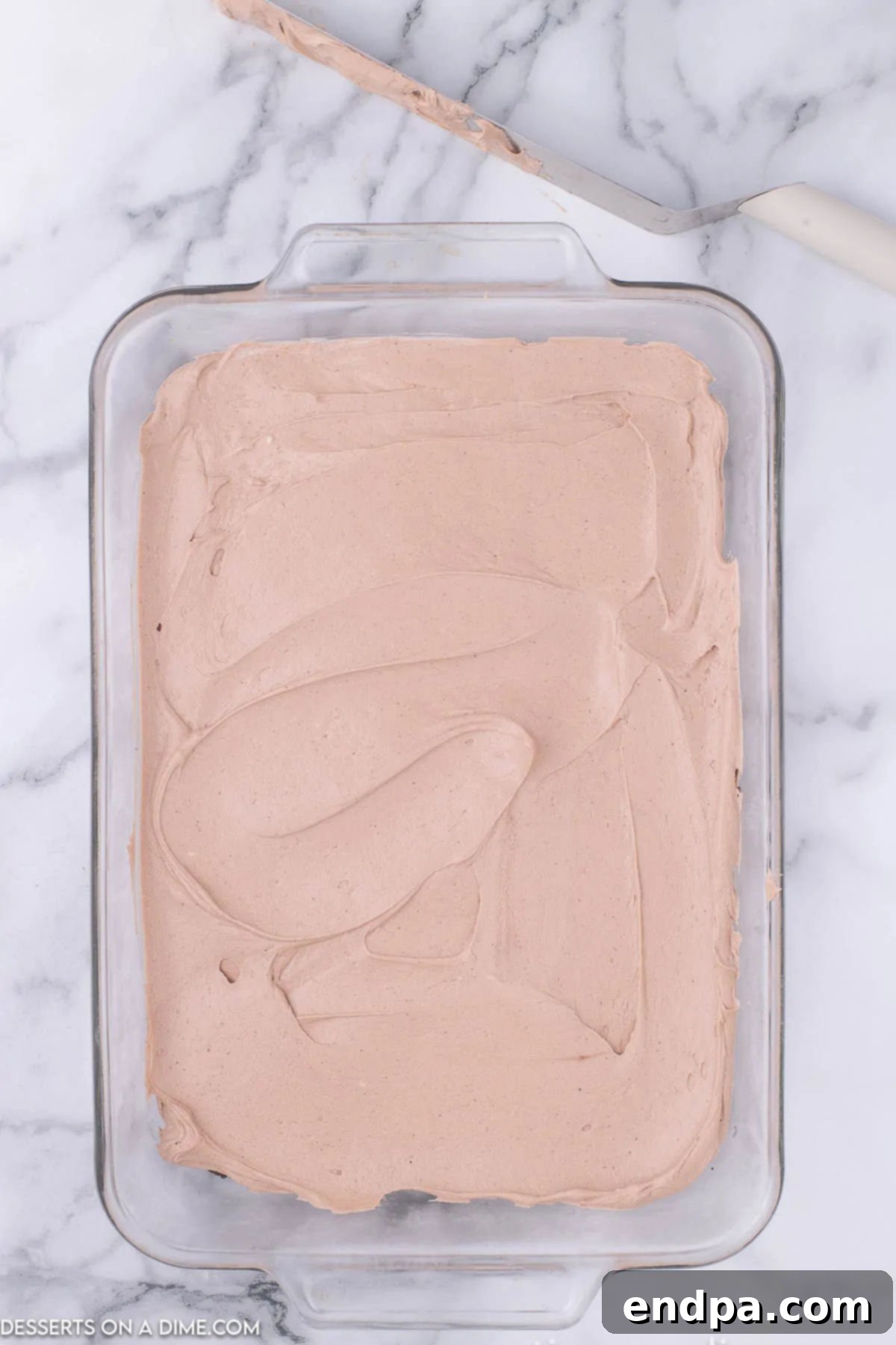 Decadent Hot Cocoa Lasagna 7 The creamy cheesecake mousse layer spread evenly over the chilled Oreo crust in the baking dish.