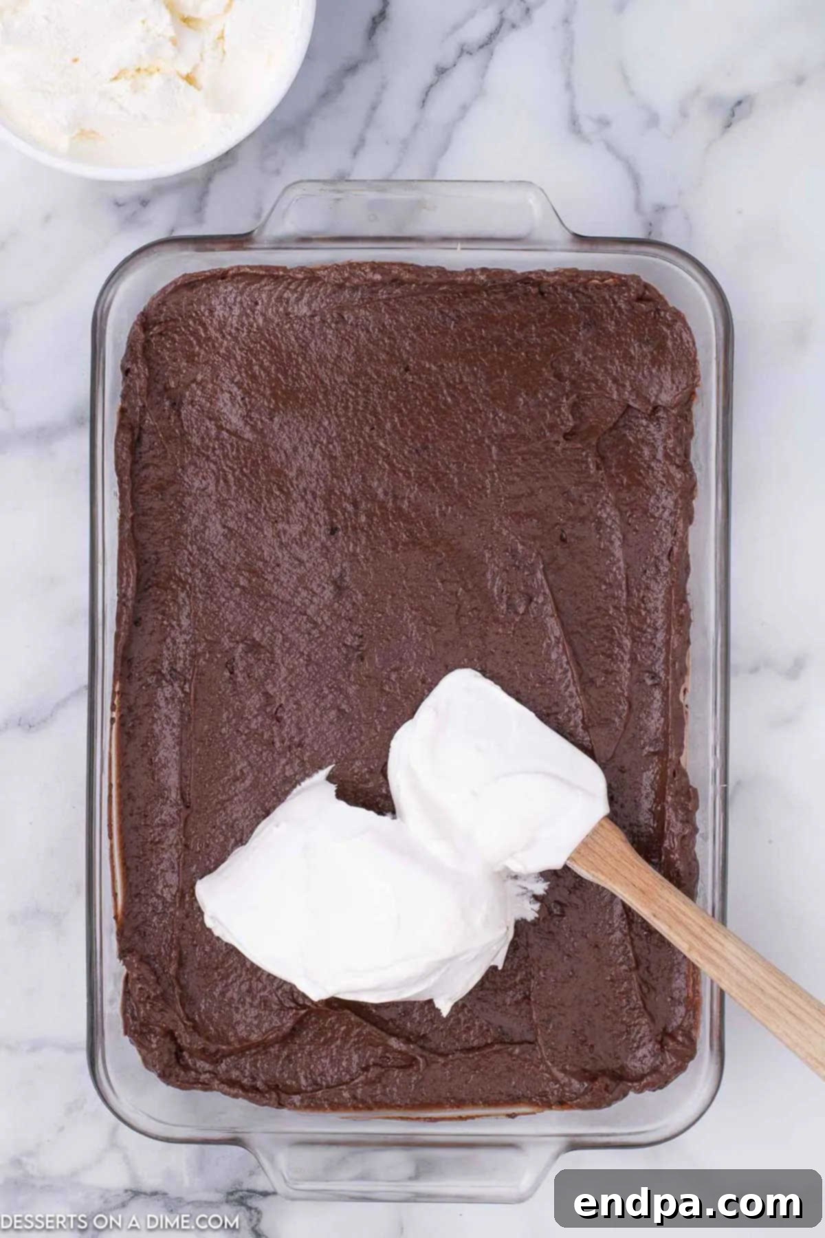 Decadent Hot Cocoa Lasagna 9 The final layer of Cool Whip or homemade whipped cream spread over the set chocolate pudding.