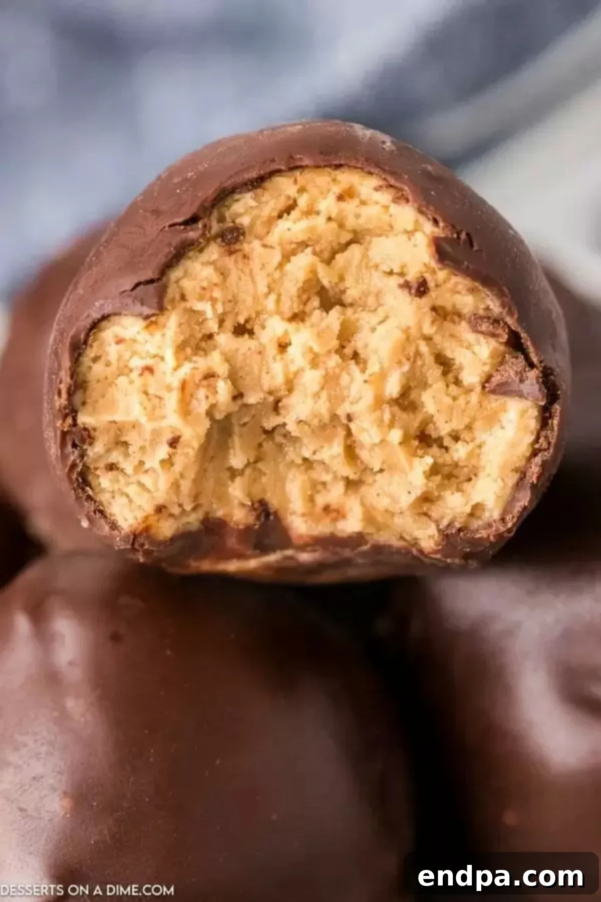 Decadent Chocolate Peanut Butter Bites 9 Several decadent chocolate covered peanut butter balls stacked together, ready to be enjoyed as a sweet treat.