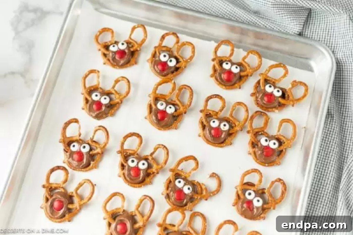 Decorating Reindeer Pretzels with Noses, Antlers, and Eyes Melted Rolo candies on pretzels with red M&Ms, pretzel antlers, and candy eyes added to create reindeer faces.