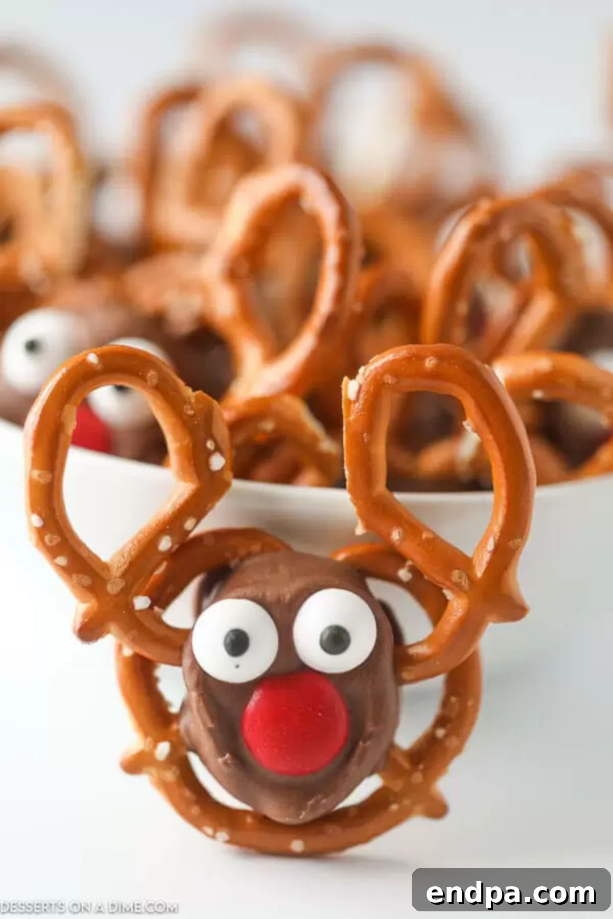 Reindeer Pretzels: A Perfect Christmas Treat Close-up of adorable Reindeer Pretzel treats in a bowl, showcasing the detailed faces and festive appeal.
