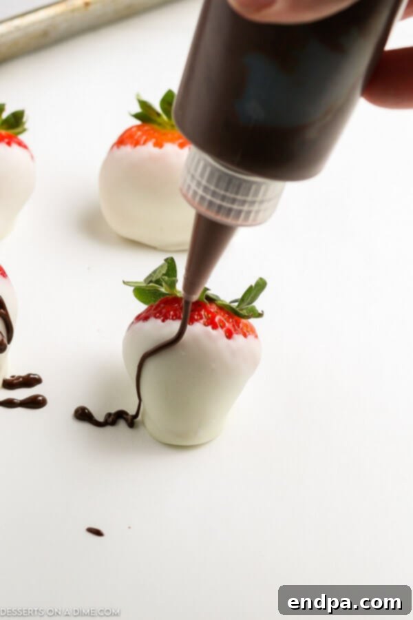 A close-up of chocolate covered strawberries artfully drizzled with white chocolate, presented on a platter.