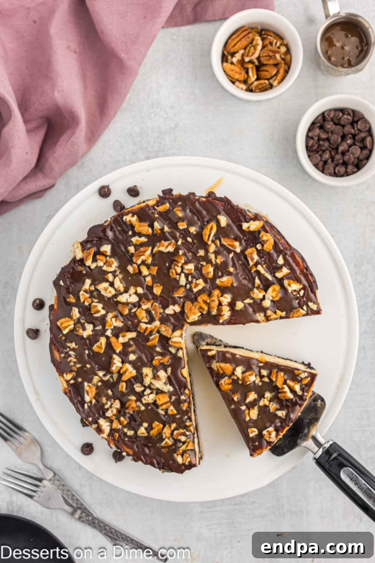 A slice of Turtle Cheesecake being cut, ready to be served and enjoyed.