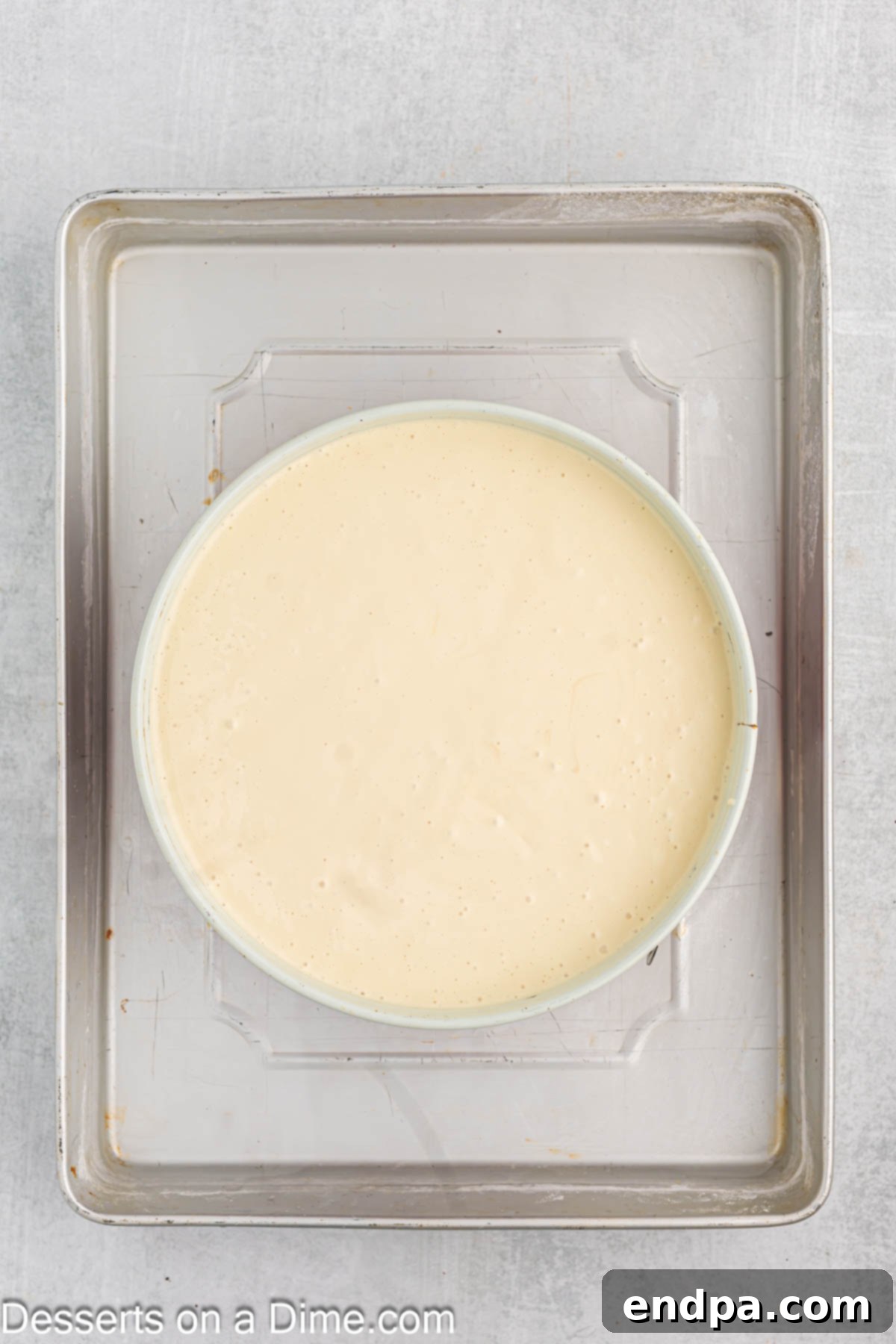 The creamy cheesecake filling being poured into the prepared Oreo crust in a springform pan.