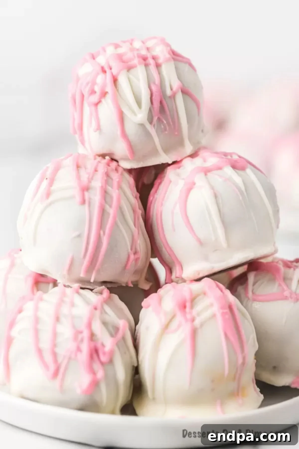 A festive platter piled high with decorated Red Velvet Cake Balls, ready for a party.
