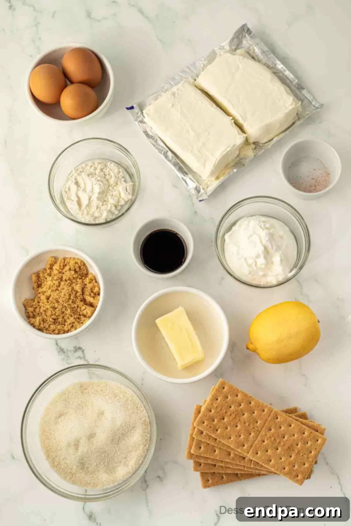 Creamy Cheesecake Delights 3 Ingredients laid out for making cheesecake bars, including graham crackers, brown sugar, butter, salt, cream cheese, granulated sugar, flour, eggs, sour cream, vanilla extract, and lemon juice.