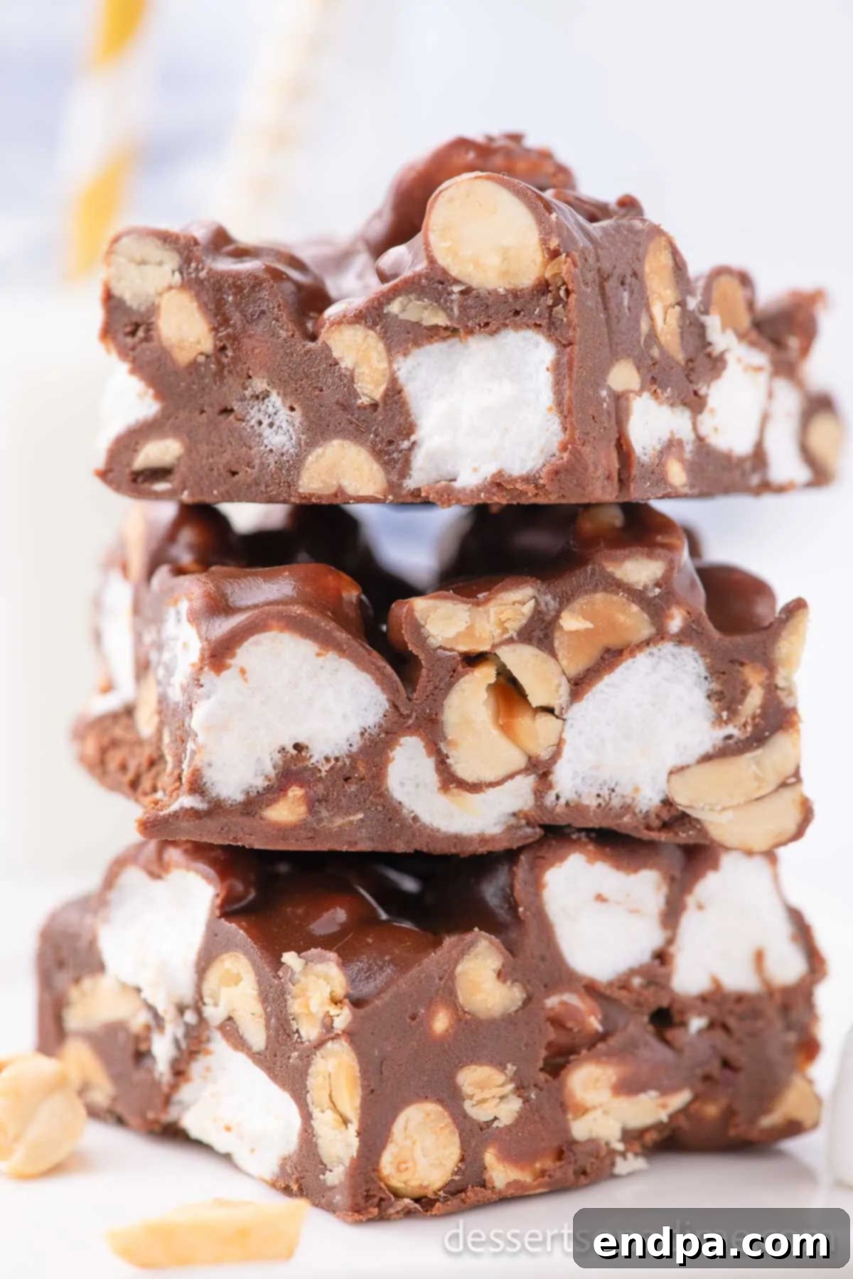 Decadent Rocky Road Dream 2 Rocky Road cut into squares and stacked together on a plate, showcasing the chocolate, marshmallow, and peanut texture.