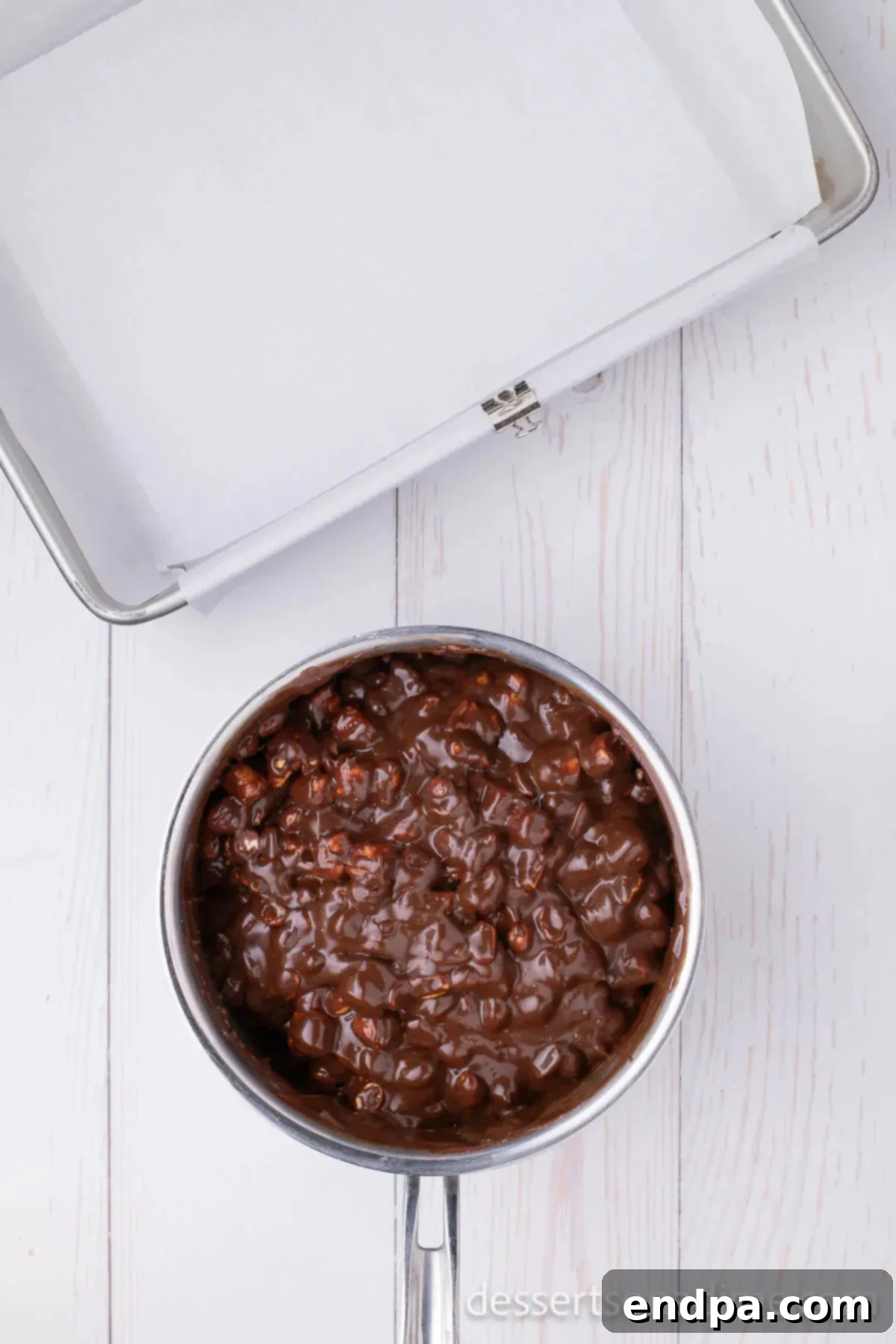 Decadent Rocky Road Dream 5 Melted chocolate mixture in a pan with dry roasted peanuts added and being stirred in.