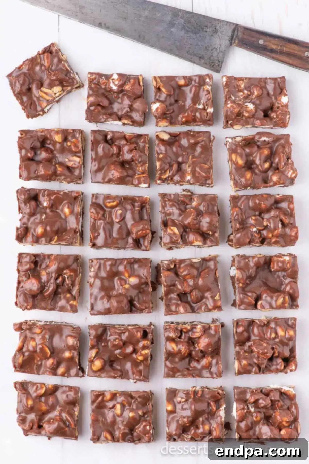Decadent Rocky Road Dream 7 The set Rocky Road candy being cut into uniform squares with a sharp knife in the baking pan.