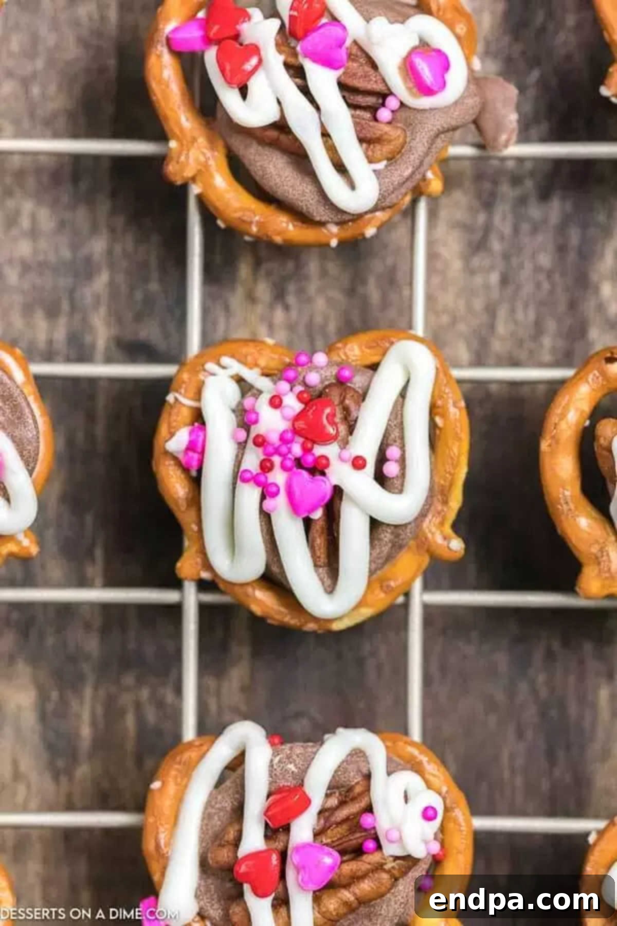 Finished Valentine's Day Rolo Pretzel Turtles arranged on a wire cooling rack, allowing the chocolate to fully set.