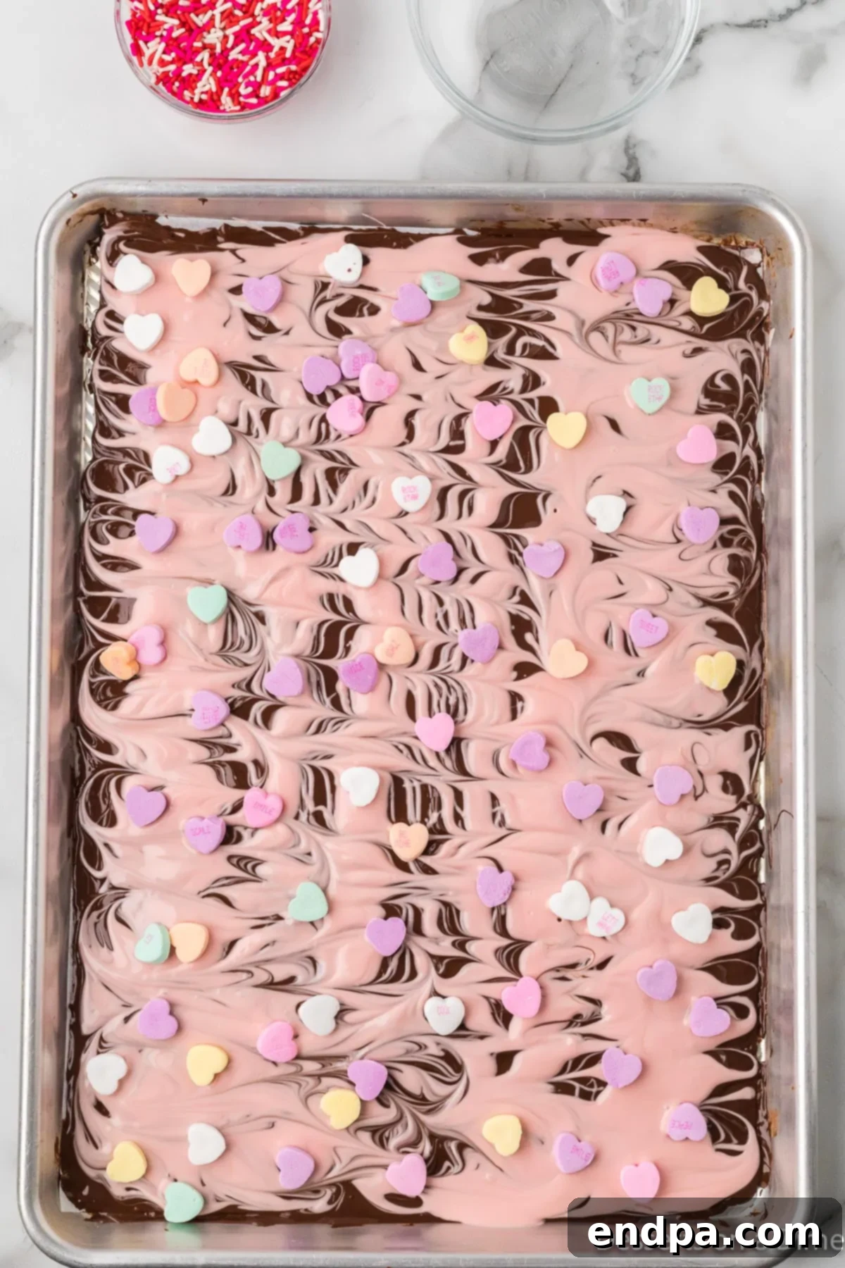 Candy hearts and sprinkles generously scattered over the swirled chocolate bark.