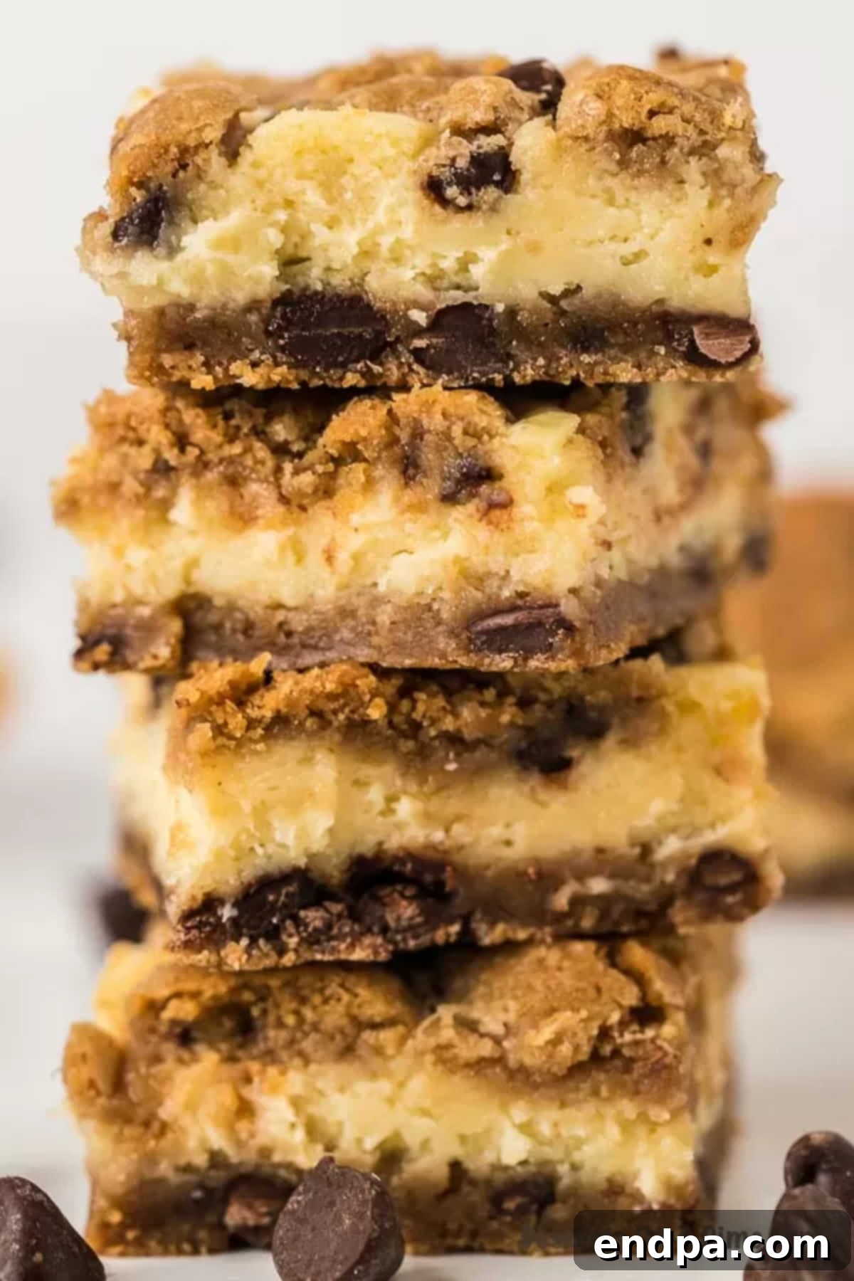 Stacked Chocolate Chip Cheesecake Bars, showcasing their delicious layers and golden-brown cookie crumble topping.